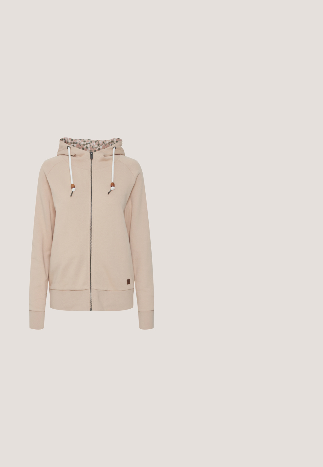 Heledane roosa zip-up kapuutsiga sviiter, mille kapuutsi vooder on lillemustriga. Valged paelad puidust aktsentidega ning ribakujundusega varrukad ja alläär.; Heledbeez tank top pehmest kangast, millel on ümar kaelus ja väike logo detail ääres. Sile tekstuur, mugav disain.; Beige puuvillaseguse kangaga lühikesed püksid elastse talje, nööri ja väikese kuldse logoga rõhuasetusega alumises vasakus nurgas. Sile tekstuur.; Beige sportlik jalats tekstureeritud ülemise osa, paelte ja toetava kannaelemendiga, puidust pinna kohal, rohelise lehestiku taustal.; Pruunide ja beežide maastikumustriga vöökott musta tõmbluku ja pruuni "Urban Classics" sildiga ees.; Kuldsete rõngaste kõrvarõngad, millel on sile, ümar disain. Omab kerget kaarust ja lilledega aktsenti. Poleeritud viimistlus.