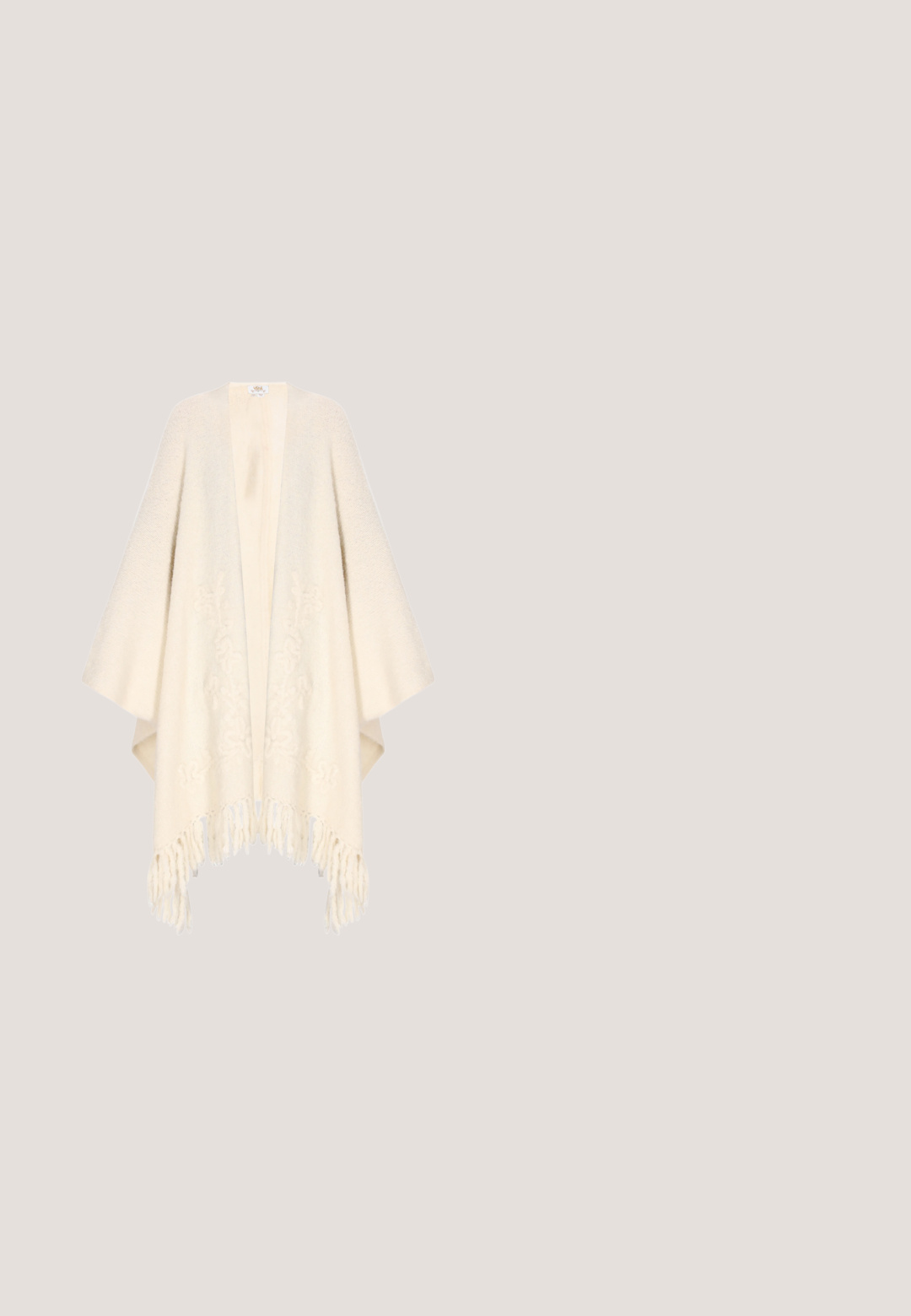 Poncho de color crema hecho de tela suave, con un diseño de frente abierto y un intrincado bordado floral. El dobladillo con flecos añade textura y detalle.; Top de crochet sin mangas color crema con tirantes anchos y capas horizontales de encaje texturizado.; Vero Moda Petite VMBALI WIDE PANTS  - Pantalones - marsala; Sandal de pala ancha tejida en amarillo con la puntera abierta y patrones florales bordados en rosa y azul en la parte superior, con una suela marrón.; Bolso beige para el hombro con relieve floral, correa anudada, pequeño logo plateado, bolsillo frontal con cremallera y charm en forma de corazón en la correa.; Tres pulseras de cuero enrolladas en colores beige, azul y oliva, unidas por un cierre dorado brillante sobre un fondo blanco.