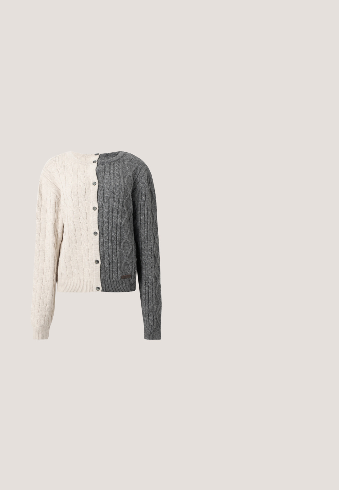 Gebreide cardigan met een splitontwerp, met crèmekleur aan de ene kant en donkergrijs aan de andere. Kabelbreisel textuur, knoopsluiting en geribbelde manchetten.; Witte lange mouwen T-shirt van zacht katoen, met een ronde hals en een slank fit ontwerp met schone naden en zonder zichtbare patronen.; Licht beige, knielange rok gemaakt van een gladde, textuurstof. Heeft een split aan de voorkant en een knoopsluiting in de taille.; Zwarte gepatenteerde leren platte schoen met een puntige neus, een kleine decoratieve band en een lage blokhak. Gladde textuur en strak ontwerp.; Beige schapenleren schoudertas met een gebogen handvat en een afgeronde vorm. De textuur is zacht en plush, met minimale hardwareaccenten.; Een paar glanzende zilveren dikke creolen met post-sluitingen op een effen witte achtergrond.
