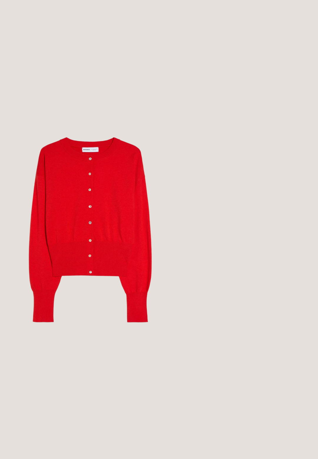 Cardigan rouge à manches longues coupé court avec encolure ronde, poignets et ourlet côtelés, et boutons blancs sur le devant.; Débardeur rouge côtelé sans manches avec encolure dégagée et dos nageur, avec une étiquette de marque noire à l’intérieur du col arrière.; Pantalon large rouge vif avec une taille haute élastique et des détails simples de coutures, fabriqué en tissu léger.; Escarpin rouge en cuir, à talon aigu de 2,5 pouces et bout pointu. Texture lisse avec un minimum de détails et une silhouette structurée.; Sac à main en cuir rouge avec une texture lisse, une forme courbée et un accent en chaîne argentée. Présente un logo embossé sur le devant.; Collier chaîne en or avec deux rangées de grosses perles rouges et de petits charms dorés en forme de feuille, espacés uniformément le long des perles.