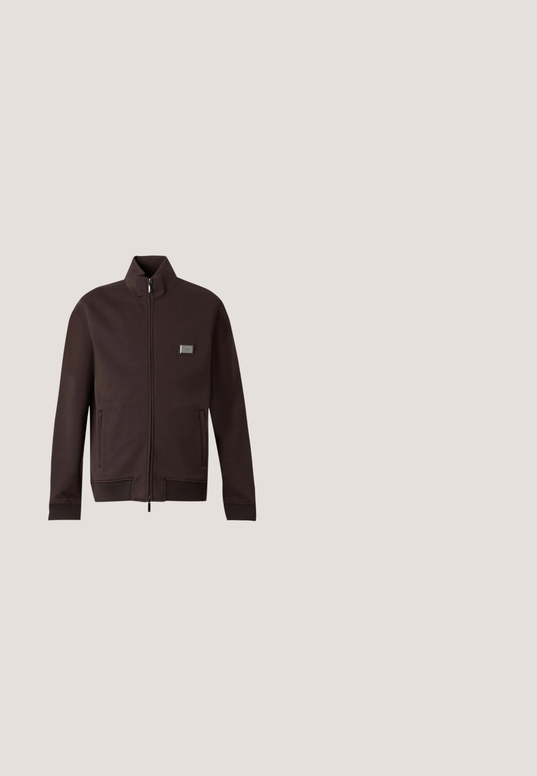 Donkerbruine jas met rits en opstaande kraag, twee zijzakken, geribbelde boorden en zoom, en een klein rechthoekig logopatch op de borst.; Mouwloos donker olijfgroen doorgestikt vest met hoge kraag, ritssluiting aan de voorkant, met ritssluiting afsluitbare zijzakken en een klein logo op de borst.; Bruine T-shirt met korte mouwen met een witte schets van een gestroomlijnde sportwagen en een klein logo eronder in het midden aan de voorkant.; Bruine taps toelopende joggingbroek met elastische tailleband en trekkoord, plat liggend op een lichte achtergrond.; Sneakers met een beige suède bovenkant, witte accenten, een brown rubberen zool en kleurrijke gestreepte details op de hiel; heeft brown veters.; Donkerbruine stoffen heuptas met diagonale ritssluiting en klein wit logo aan de voorkant, tegen een effen lichte achtergrond.