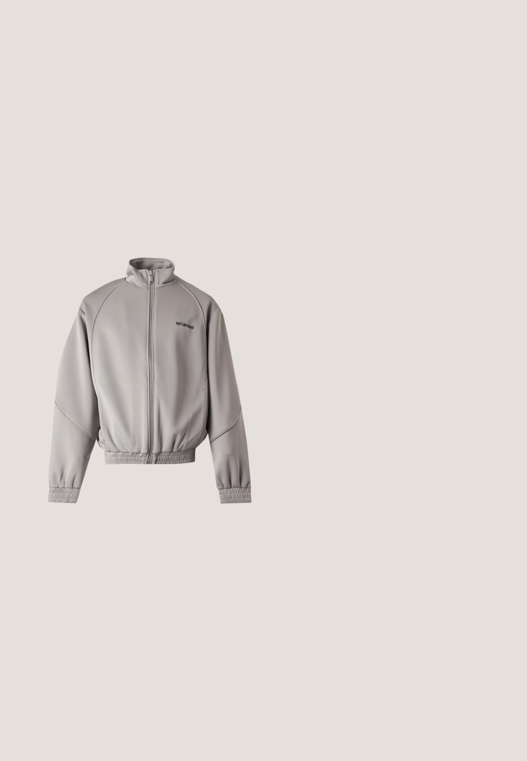 Hellgraue Jacke mit Reißverschluss, hohem Kragen, langen Ärmeln, elastischen Bündchen und Saum sowie kleinem schwarzem Text auf der oberen linken Brust.; Dunkelgraues Sportshirt aus strukturiertem Stoff. Mit einem seitlichen Schlitz am Saum und einem kleinen Logo-Tag in der unteren linken Ecke.; Hellgraue Sweatpants aus einem glatten, leichten Stoff mit schwarzen Akzenten. Sie verfügen über einen elastischen Bund mit Kordelzug und seitlichen Taschen.; Weißer niedriger Canvas-Sneaker mit weißen Schnürsenkeln und dicker strukturierter Sohle, im Profil auf weißem Hintergrund dargestellt.; Schwarze Umhängetasche mit strukturiertem Design im Rastermuster, verstellbarem Riemen und Reißverschlusstasche mit silberfarbenen Beschlägen.; Silberfarbige rechteckige digitale Quarzuhr mit schwarzem Zifferblatt, weißen Zeigern und Edelstahlarmband; verfügt über ein digitales Display und Tasten an der Seite.