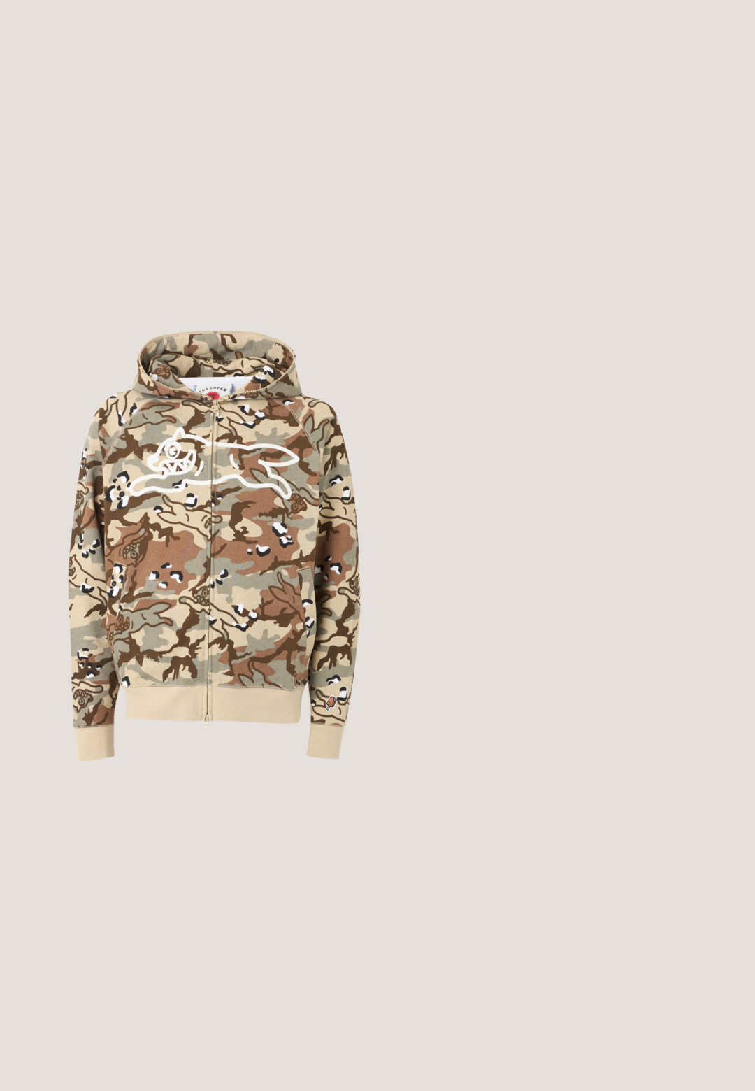 Sweat à capuche zippé camouflage beige, marron et vert avec un contour blanc à l'avant représentant un chien de dessin animé courant, avec des poignets et une ceinture beiges.; T-shirt blanc arborant un graphisme d'escaliers et un crâne sur un fond rouge avec des accents et des détails noirs, mettant en valeur la profondeur et la texture.; Pantalon kaki à jambe droite avec des détails de coutures visibles, des passants de ceinture, une fermeture par bouton à l'avant, et des panneaux en forme de patchs aux genoux.; Baskets montantes en cuir marron avec semelle en caoutchouc noir, dotées d'une doublure en polaire grise, d'accents orange et de détails perforés. Logo DC visible.; Lunettes de soleil œil de chat en écaille de tortue avec des verres bleu clair et des détails discrets sur la monture et les branches.; Sac fourre-tout à motif camouflage en tissu texturé avec deux poignées. Présente un logo blanc bien visible sur un côté.