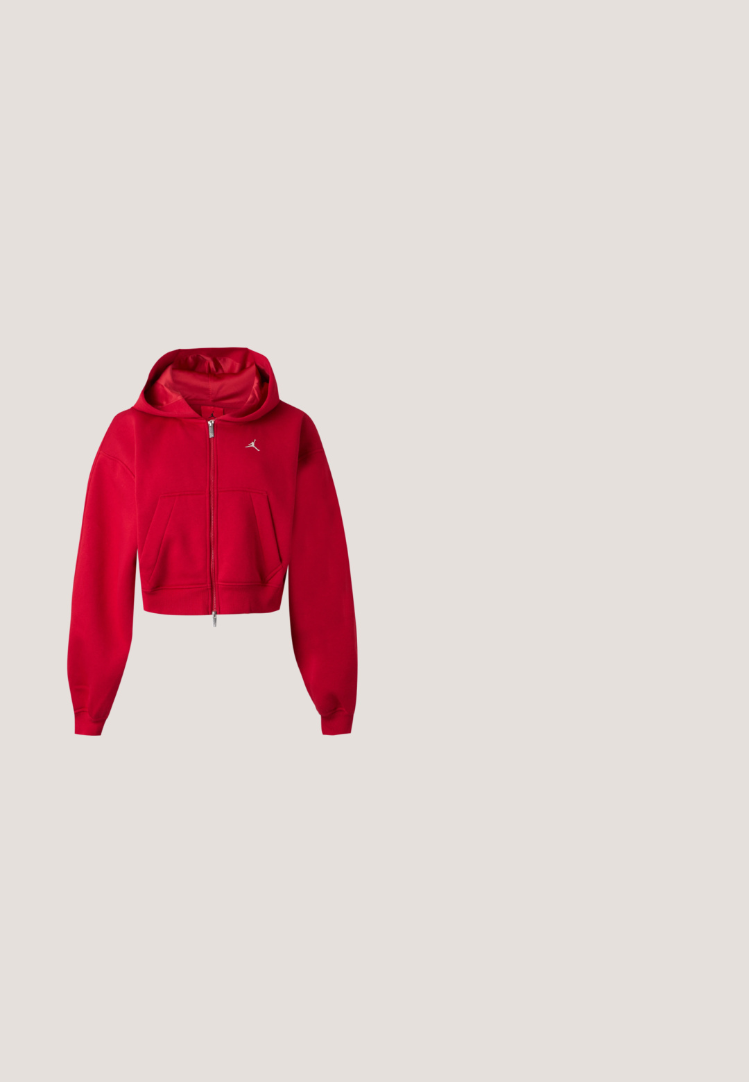 Sweat à capuche rouge court zippé avec poches kangourou et petit logo blanc Jumpman sur la poitrine gauche.; Haut court noir à une épaule avec logo Jumpman rouge brodé au centre de la poitrine sur un fond uni.; Pantalon de jogging noir fuselé avec ceinture et poignets élastiques, petit logo sur la partie supérieure de la cuisse, poches avant, texture de tissu lisse.; Baskets de sport rouge vif avec semelles épaisses, larges sangles et longues lanières en ruban autour de la cheville, présentées sur un fond blanc uni.; Sac à épaule en forme de croissant noir avec une sangle réglable, fermeture éclair argentée et une petite plaque argentée à l'avant avec un charme décoratif attaché.; Boucles d'oreilles en argent avec une finition polie, présentant une forme ronde simple et une fermeture à tige pour un port sécurisé.