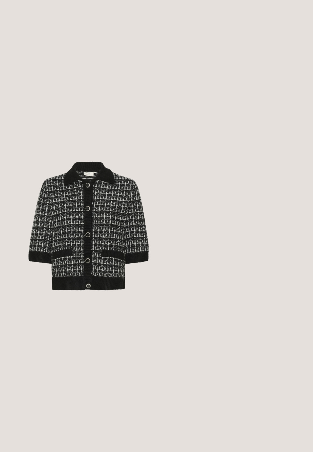 Cardigan a rayas en blanco y negro con cuello, mangas cortas, cuatro botones grandes y dos bolsillos frontales. Material de punto texturizado.; Camiseta negra de manga corta con cuello redondo adornado con perlas y la palabra "Karl" bordada en escritura blanca debajo del cuello.; Falda de tweed negra con un patrón de cuadros, adornada con lentejuelas y pequeños acentos florales, con un dobladillo deshilachado y un diseño ajustado.; Zapato negro de tacón de aguja con punta puntiaguda y detalles de cuentas similares a perlas a lo largo de los lados y la zona de los dedos.; Bolso de mano plateado con glitter, de forma triangular, acabado texturizado, acentos de cuero negro y una correa para el hombro. Detalle del logo en el lateral.; Pendientes redondos con una banda de tono plateado con texto en relieve, adornados con múltiples cristales transparentes que crean una superficie brillante.