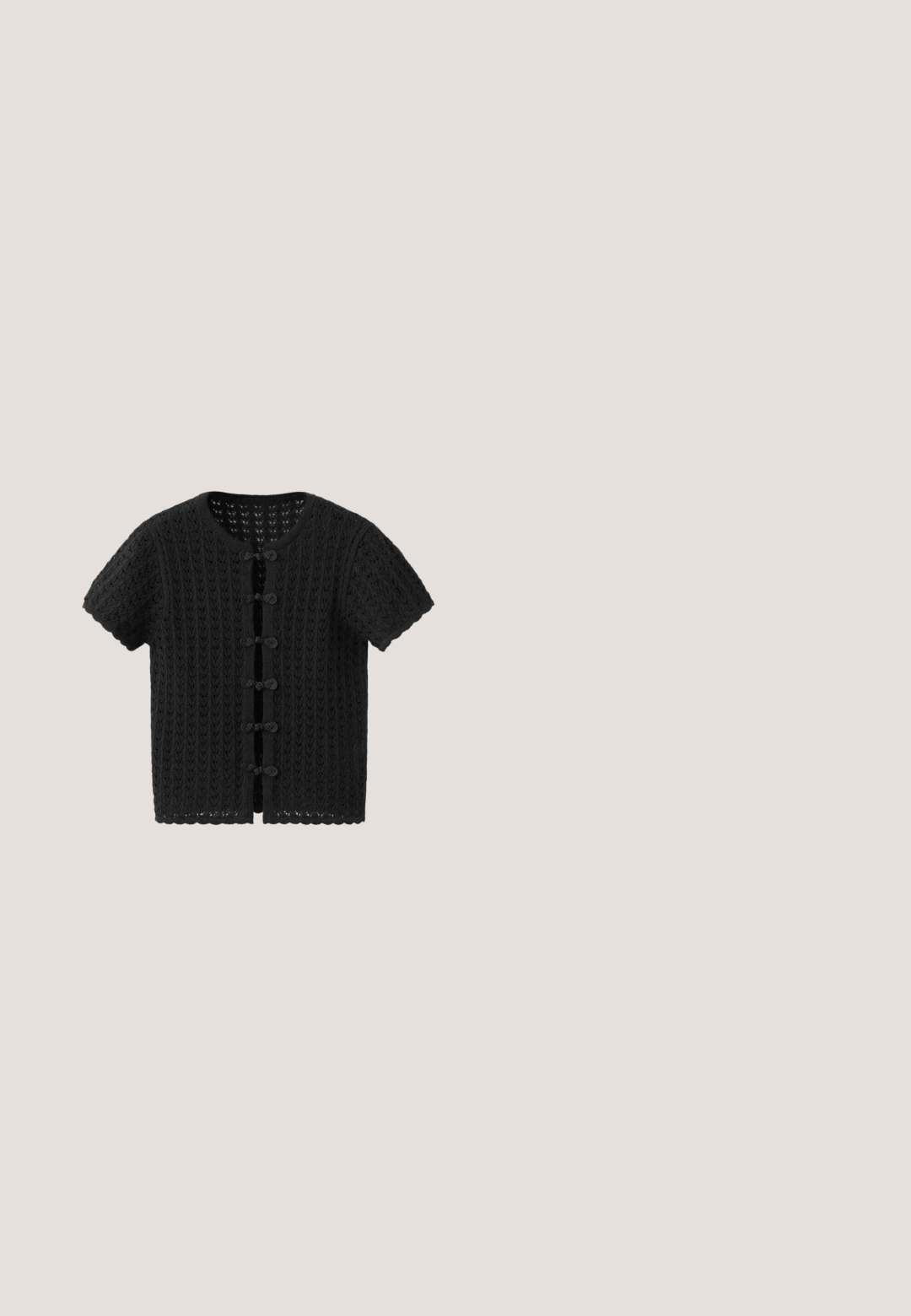 Cardigan noir à manches courtes en crochet avec encolure ronde et cinq fermetures décoratives à boutons bouclés sur le devant.; Haut blanc sans manches à pois noirs avec un profond décolleté arrondi.; Shorts blancs à pois noirs avec bandes latérales noires, taille élastique, devant plat et coupe ample.; Chaussure Mary Jane plate noire avec des clous ronds argentés et une sangle à boucle, vue de profil sur fond blanc.; Lunettes de soleil noires de forme ovale avec des montures épaisses et des verres foncés, comportant de petits éléments décoratifs sur les branches et un logo de marque.; Petit sac à main en tissu crème recouvert d’appliques florales superposées et d’une poignée en bois courbée.