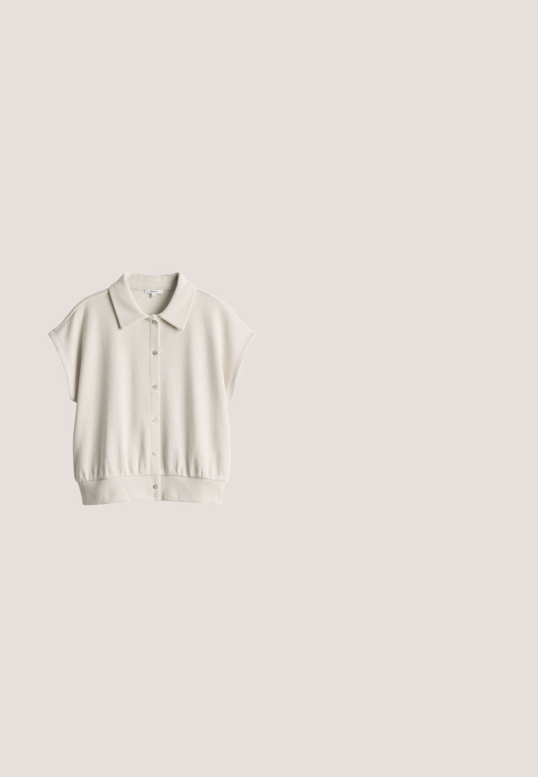 Cardigan en maille courte manches couleur crème avec col et fermeture à boutons devant, doté d’une coupe légèrement ample et d’un ourlet côtelé.; Haut sans manches en coton beige clair avec encolure ronde et étiquette affichant le nom de la marque OPUS au niveau du col arrière.; Pantalons beige à jambes larges en tissu léger avec une taille élastique et un cordon de serrage, présentant des coutures verticales sur le devant.; Sandale beige en daim à bout ouvert, plate avec une large bride et une semelle intérieure rembourrée, présentée sur fond blanc.; Lunettes de soleil surdimensionnées à motif écaille de tortue avec une monture large et des verres teintés beige, présentées sur un fond blanc.; Sac à main rectangulaire tissé couleur fauve avec deux longues poignées en cuir lisse et une fermeture éclair sur un côté.