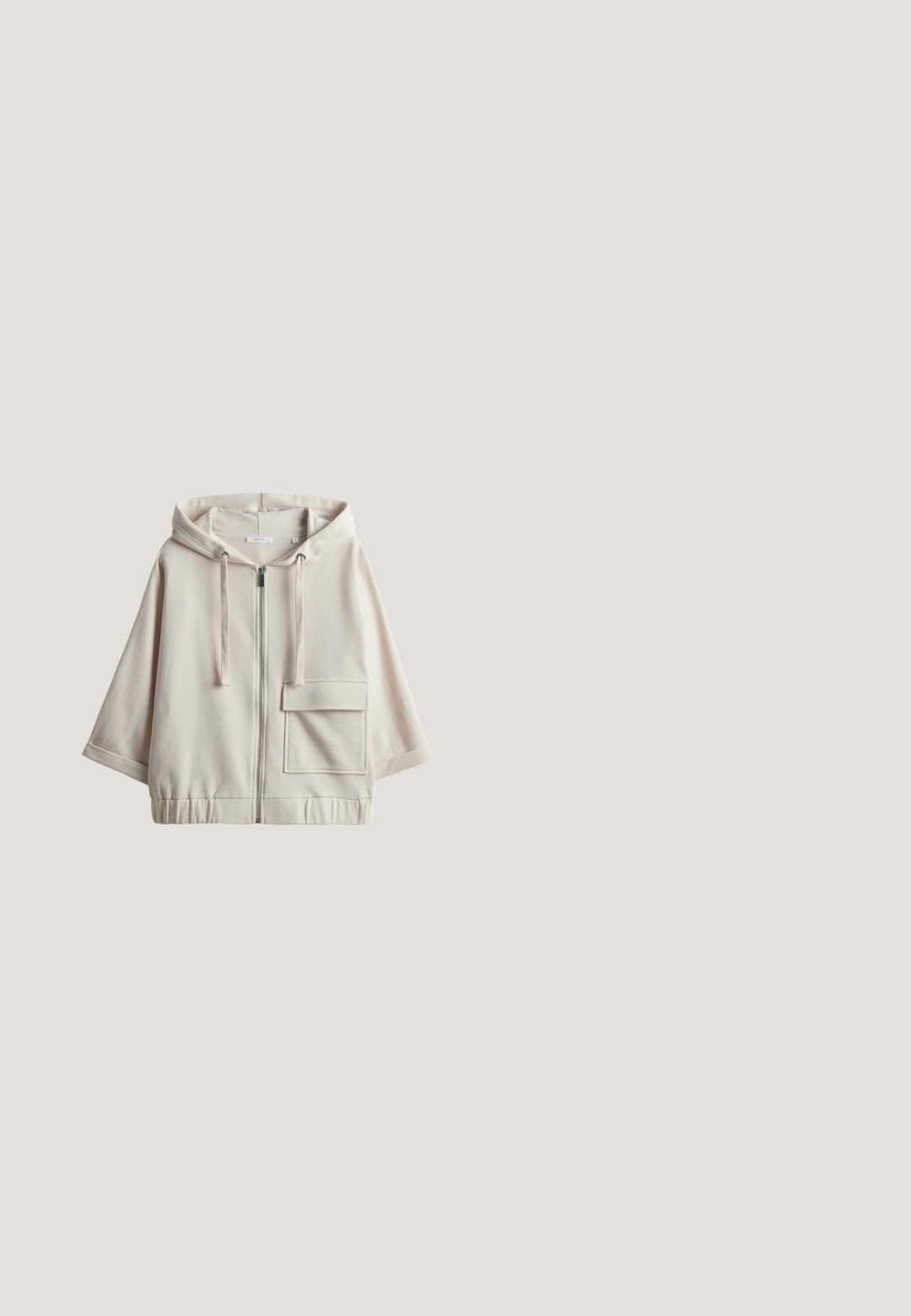 Beige hooded zip-up sweatshirt met een grote voorzak, een losse pasvorm, elastische tailleband en een soepele katoenmix textuur.; Beige oversized korte mouw sweatshirt met verlaagde schouders en ronde halslijn, weergegeven op een witte achtergrond.; Lichtbeige elastische short met koordsluiting aan de voorkant, zijzakken en geplooide details, gemaakt van gladde stof.; Beige sportschoen met suède- en meshmateriaal, vetersluiting, gestructureerde zijkanten en rubberen buitenzool.; Beige gewatteerde tote bag met dubbele handvatten, een voorvak en verzamelde details aan de zijkanten. Gladde textuur met een minimalistisch ontwerp.; Verstelbare zilveren koordarmband met een centraal open klavertjeviervormige bedel en een kleine hartbedel aan één uiteinde van het koord.