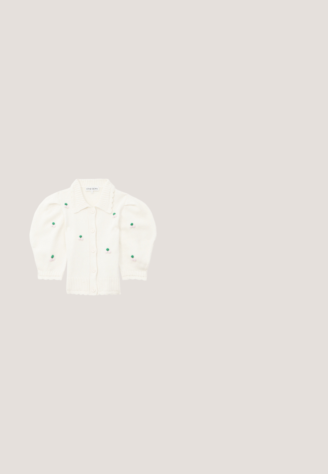 Hvid strikket cardigan med en bølget krave, knapper og puffærmer. Har grønne og lyserøde broderede blomsterdetaljer.; Lyserød bluse med flæsekantede ærmer og V-udskæring. Den har knaplukning foran og en tætsiddende bodice, der udvides til en peplum-stil.; Lyserød nederdel med små lilla, orange og gule blomster på, samt legende katte illustrationer spredt ud over stoffet.; Lyserøde patentlæder balletflade sko med firkantet tå, spænde detalje og flad gummisål. Glat tekstur hele vejen igennem.; Hårsløjfe af cremefarvet stof med en lille sølvfarvet kronevedhæng ved knuden, vist på en lysegrå baggrund.; Lyserød hjerteformet lædermøntpose med håndledsrem og guldlås, mærket med lille gyldent "Furla"-tekst.