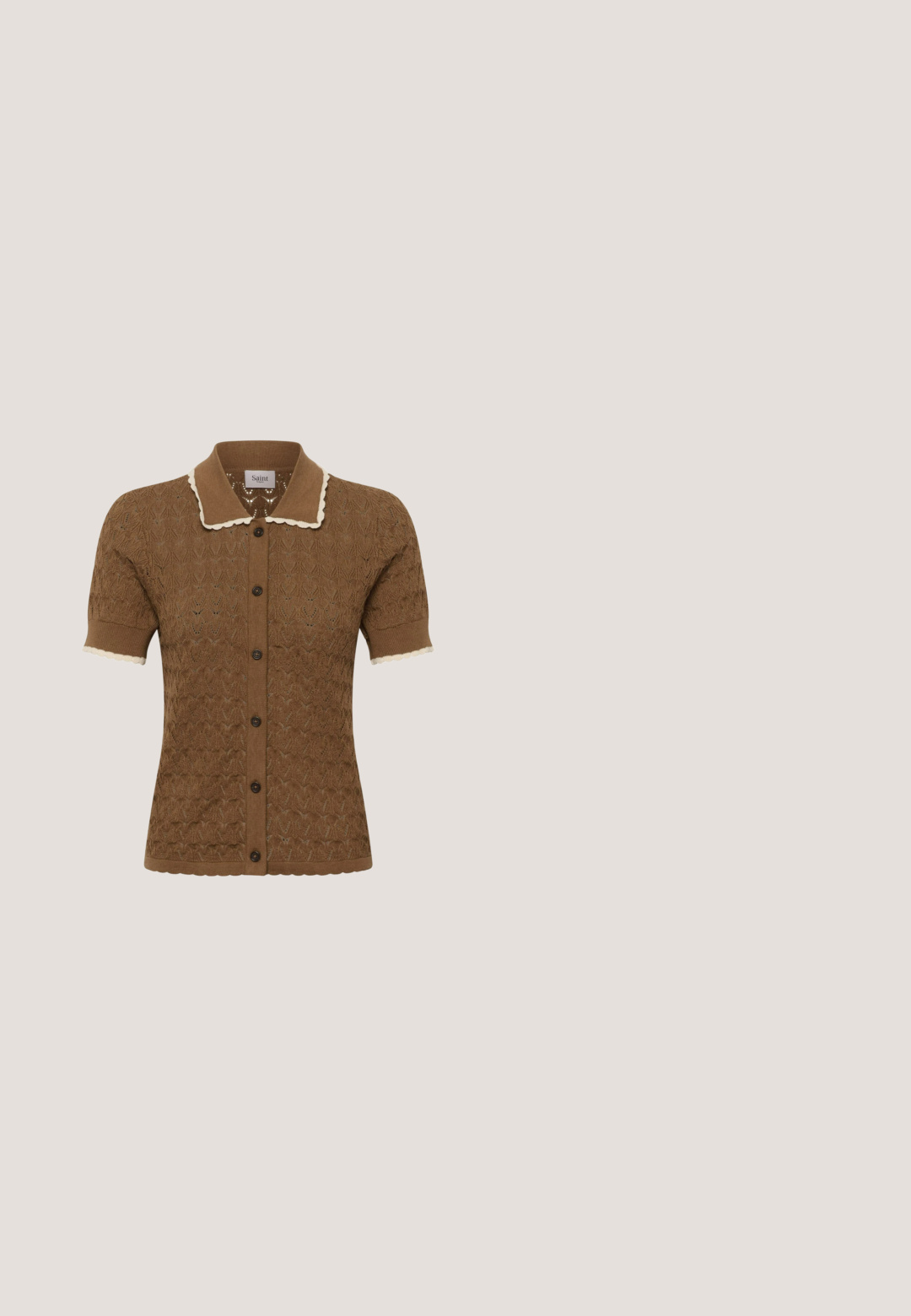 Brun kortærmet strikket cardigan med bølget cremefarvet kant på krave og ærmekanter, med knaplukning foran og delikat blonde mønster.; Blomstret kjole i hvid og blå med smocksom bodice, korte puffede ærmer og lagdelt kant. Fremstillet af letvægtsstof.; Brun spidse flade sko med dekorativ sølvdetalje og rosa ankelbindebånd på hvid baggrund.; Rektangulære skildpaddesolbriller med brune tonede linser og et guld "C" emblem på stængerne, sat mod en ensfarvet lys baggrund.; Vævet læderhåndtaske i blødt grå, med et rundt håndtag og struktureret overflade med en buet top, minimal hardware.; Delikat gyldent og klart perlekæde med dobbelt snor med små runde perler og dråbeformede vedhæng i enderne.