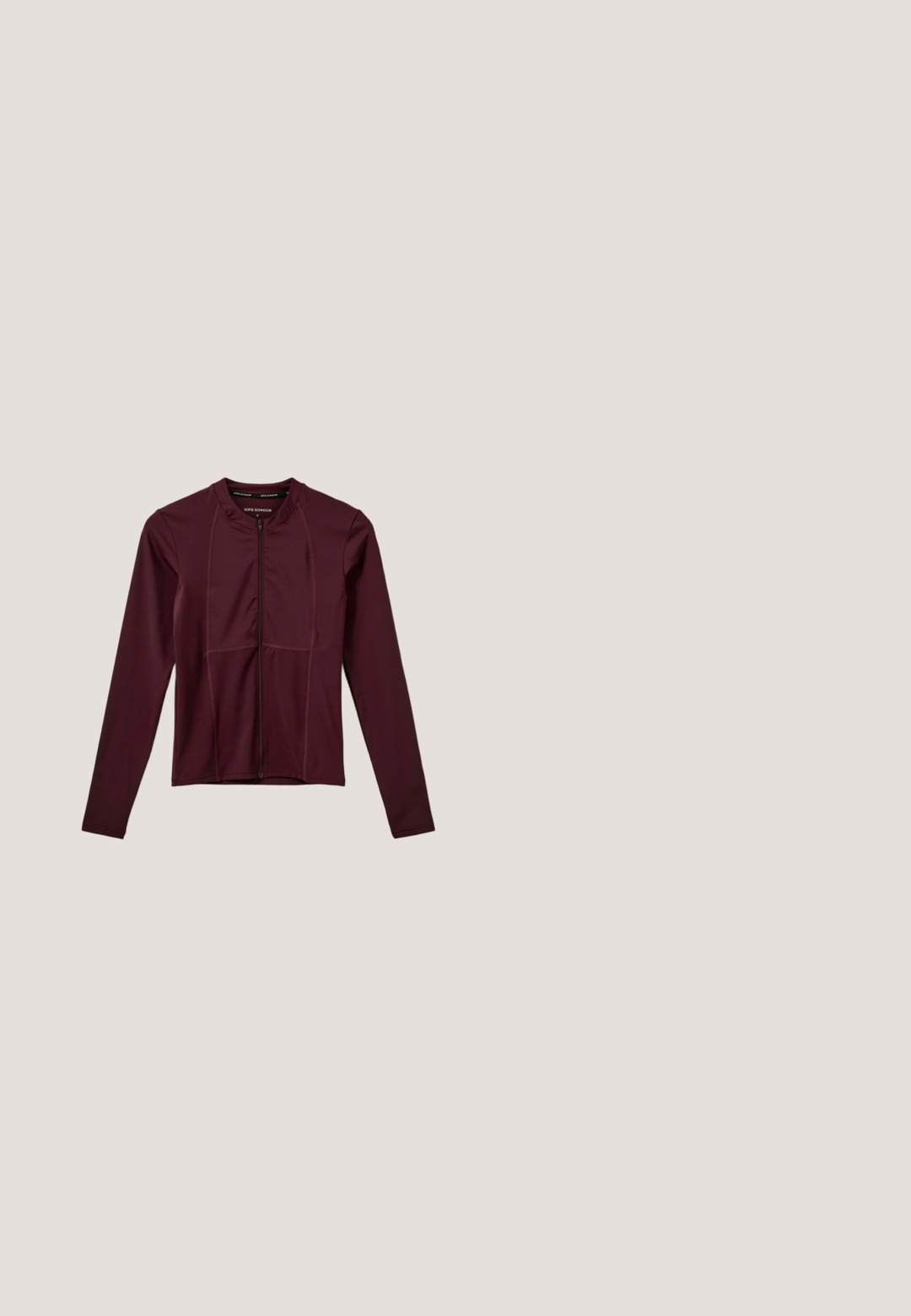 Langärmlige, kastanienbraune Sportjacke aus stretchy Material; mit einem Frontreißverschluss und Panelelementen entlang des Oberkörpers.; Kurze ärmels, cropped, brauner Sportoberteil aus glattem, leichtem Stoff mit einem subtilen Glanz und einem kleinen Logo auf der Brust.; Zweischichtige rosafarbene Sportshorts mit sichtbarer weinroter Innenschicht, elastischem Bund und kleinem weißen Nike-Logo am rechten Bein.; Schwarzer und pinker Laufschuh schwebt über Kies und Moos in einer Waldumgebung im Freien.; Bordeauxfarbene Nike-Tasche mit schwarzen Griffen und weißem Nike-Swoosh-Logo vorne vor weißem Hintergrund.; Rhodium-beschichtetes Armband mit roten Kristallen, das ein zartes Kettendesign und einen Karabinerverschluss aufweist.