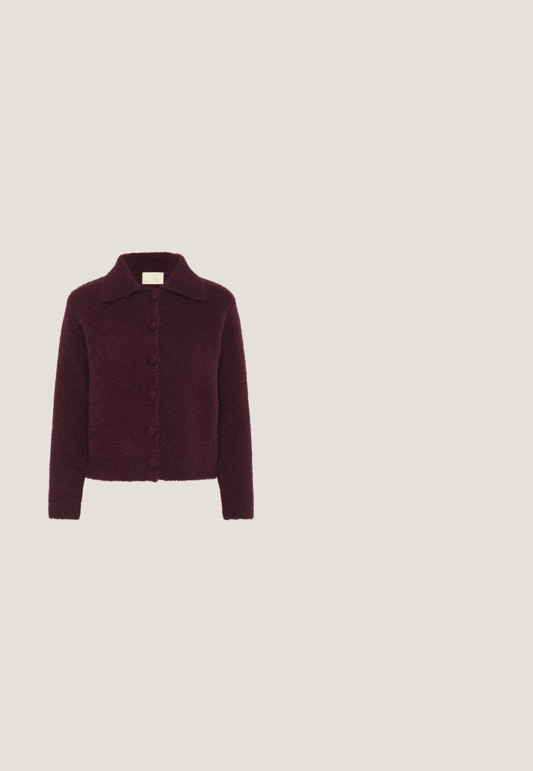 Cardigan abotonado texturizado de color púrpura oscuro con manga larga y cuello estilo spread, fotografiado sobre un fondo blanco.; Blusa burdeos de manga larga con cuello redondo, mangas fruncidas y un ligero brillo. Cuenta con un cierre de cremallera en la parte posterior.; Pantalones de pierna ancha burdeos con cintura elástica, cordón ajustable y bolsillos laterales. Fabricados con una tela suave y lisa, con un corte relajado.; Zapatos de tacón con tiras en charol burdeos, puntera afilada, tiras decorativas y detalles en tono dorado. Altura del tacón de 5 cm.; Bolso de mano de cuero tejido color granate con asa curva, ribete blanco, cremallera plateada y correa desmontable de tela ancha para el hombro sobre fondo liso.; Par de pendientes de metal con acabado plateado y diseño abstracto de bucles entrelazados sobre un fondo blanco.