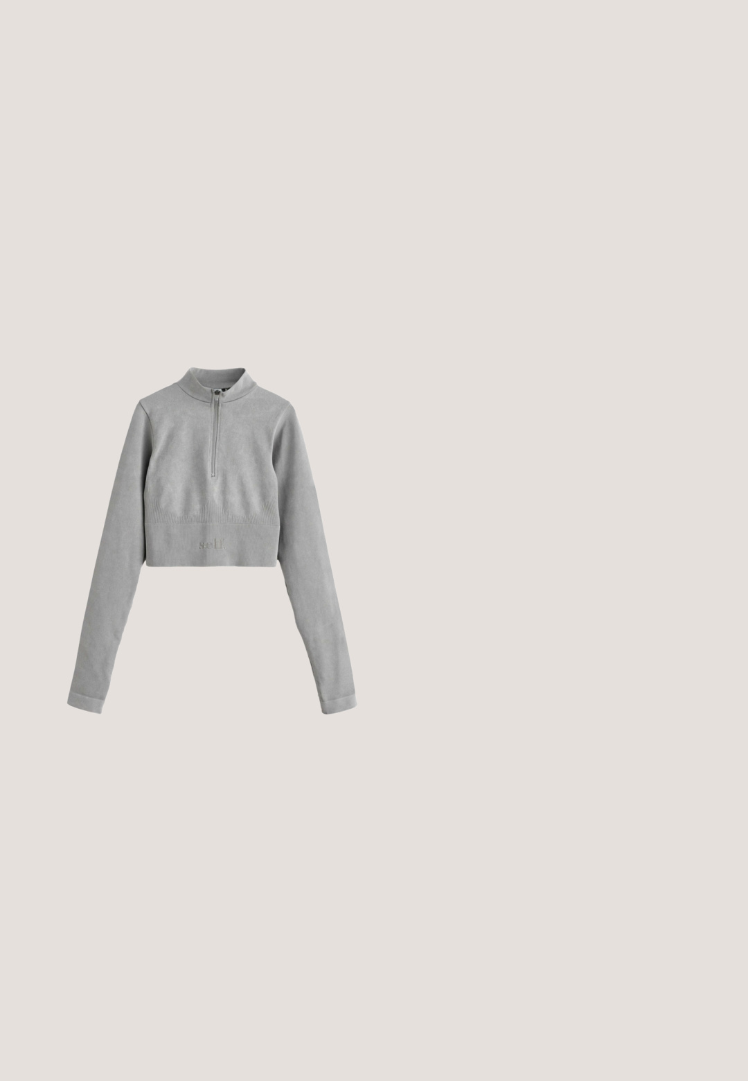 Gekürzter grauer Pullover mit einem Viertelreißverschluss, langen Ärmeln, gerippter Textur und dezentem Logo-Detail am Saum. Weiche Stoffoberfläche.; Beiges sportliches Kurzarmoberteil mit hohem Kragen und Frontreißverschluss, mit geschwungenen Nähten und kleinem weißem Logo auf der Brust.; Grauer, gerippter Sport-BH mit rundem Ausschnitt, breiten Trägern und dezentem Logodetail am unteren Rand. Weiches, nahtloses Material.; Hochtaillierte blaue Shorts aus dehnfähigem Material, mit flachen Nähten und glatter Oberfläche, entworfen für Komfort und Beweglichkeit.; Hellbeiger Slip-On Sneaker mit geripptem Strickobermaterial, abgerundeter Spitze und dicker, strukturierter Sohle für den Freizeitbereich.; Hellgraue Tragetasche mit zwei dunkelgrauen Griffen und subtilen vertikalen schwarzen Mustern auf der Vorderseite, fotografiert vor einem weißen Hintergrund.