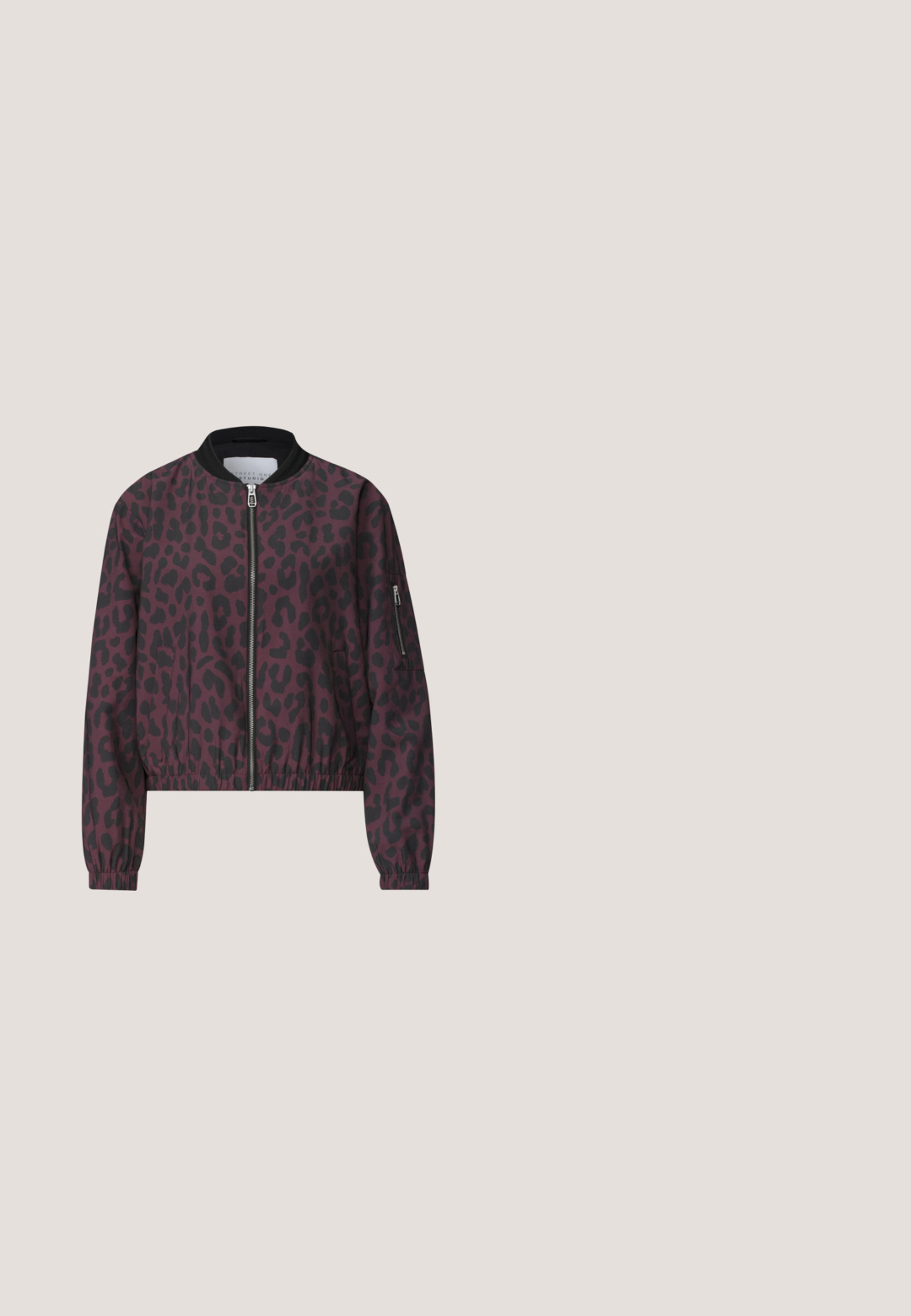 Bomberjakke med sort og mørk lilla leopardprint, foran lynlås, sort krave, elastiske manchetter og lynlåslomme på venstre ærme.; Lyserød langærmet V-hals sweater med guldknapdetaljer på manchetterne, lavet af blødt materiale med et slankt, tætsiddende design.; Lange, røde bukser med vide ben, elastik i taljen og snørre, lavet af let, let skinnende stof.; Ankelstøvler i pink og sort slangeskindsprintlæder med en struktureret finish, der har en unik buet sort gummisål.; Stor bordeaux skuldertaske med tekstureret plisseret stof og to mørkebrune afrundede håndtag.; Guldfarvede metaløreringe med et bladeformet design, der har en metallisk perleaccent nederst. Glat tekstur og minimalistisk stil.