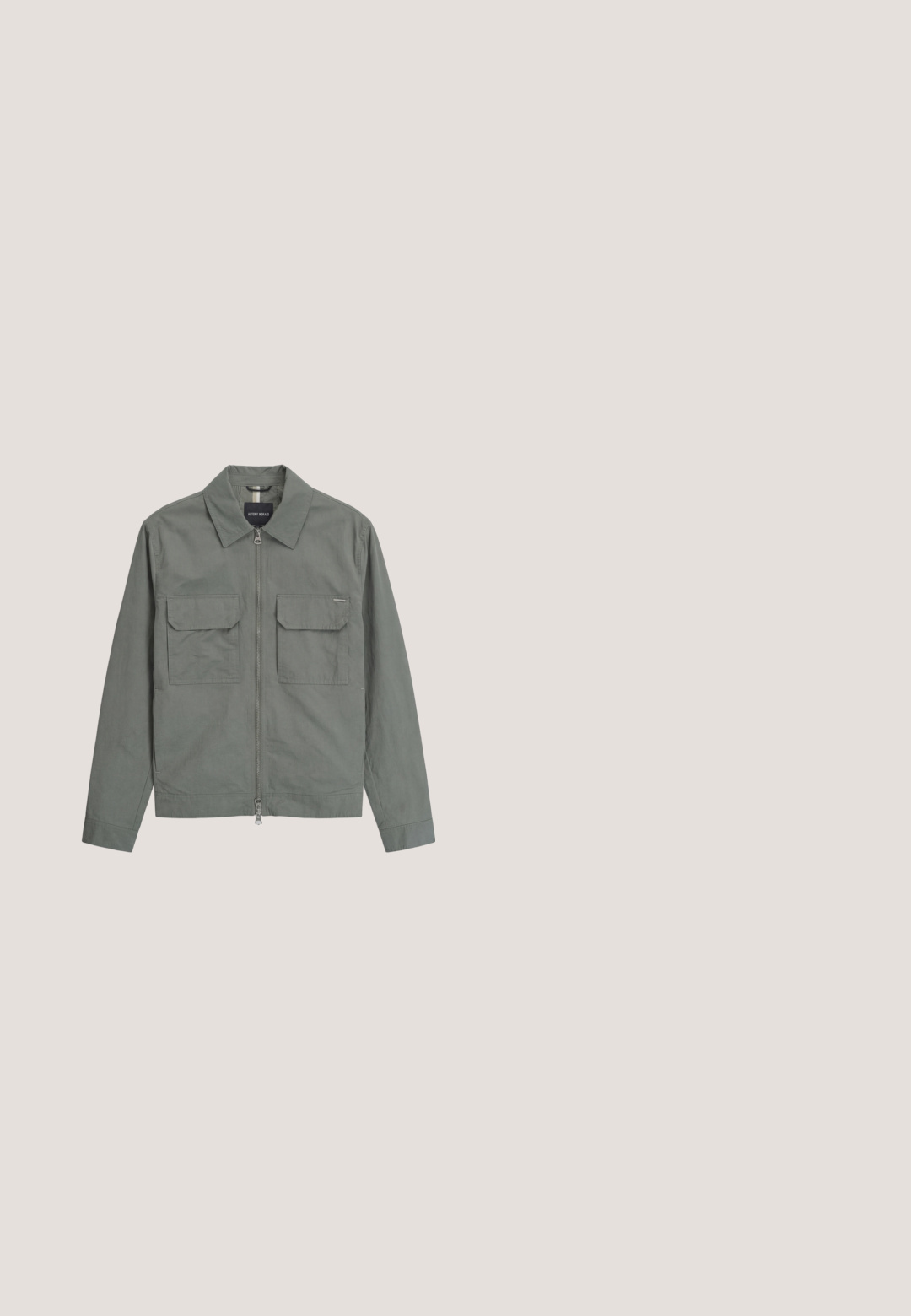Chaqueta gris con cremallera, dos bolsillos delanteros con solapa, mangas largas y cuello puntiagudo, extendida sobre un fondo blanco.; Sudadera gris hecha de una mezcla de algodón, con cuello redondo y puños de canalé. Un pequeño logo de diamante negro está bordado en el pecho.; Camiseta blanca de manga corta hecha de algodón suave, con cuello redondo y un sutil detalle de logotipo en relieve en el lado izquierdo del pecho.; Jeans de mezclilla azul claro con pierna recta, cinco bolsillos y cierre de botón; presentan áreas desgastadas y sutiles detalles de costura.; Botas Chelsea de cuero negro con paneles laterales elásticos, punta redonda y suela de goma texturizada. Detalle de costura sutil a lo largo del borde.; Funda rectangular compacta de tela gris con bolsillo frontal con cremallera y tiradores de cremallera negros, etiquetada "Karl Lagerfeld Jeans" en la parte frontal.