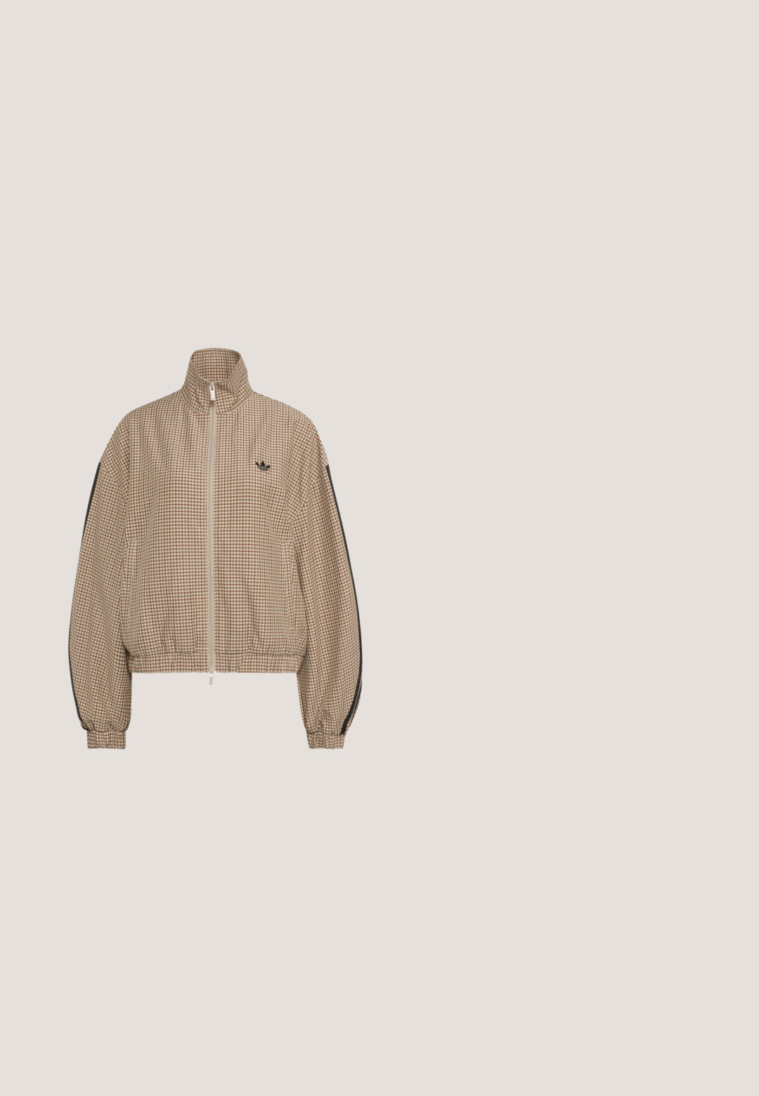 Braune und beige klein kariertes Reißverschlussjacke mit hohem Kragen, elastischen Bündchen und Saum, schwarzen Streifen an den Ärmeln und kleinem schwarzem Logo auf der Brust.; adidas Originals LEO PRINT SATIN - T-Shirt print - multicolor bronze strata; Weit geschnittene Hose mit braun-schwarzem Schlangenhautmuster, weißen Seitenstreifen und elastischem Bund, mit kleinem Adidas-Logo.; Beine mit gerippten lavendelfarbenen Socken mit weißen überkreuzten Riemen, kombiniert mit weißen Ballettschuhen mit schwarzem Rand auf grünem Boden.; Schwarze Handtasche aus Lackleder mit abgerundeter Form, doppelten Tragegriffen, silbernen Akzenten und einem auffälligen weißen Logo auf der Vorderseite.; Silberne Creolen mit dem Wort "Perfect", das innen in jedem Ohrring aus Strasssteinen geschrieben ist, vor weißem Hintergrund.