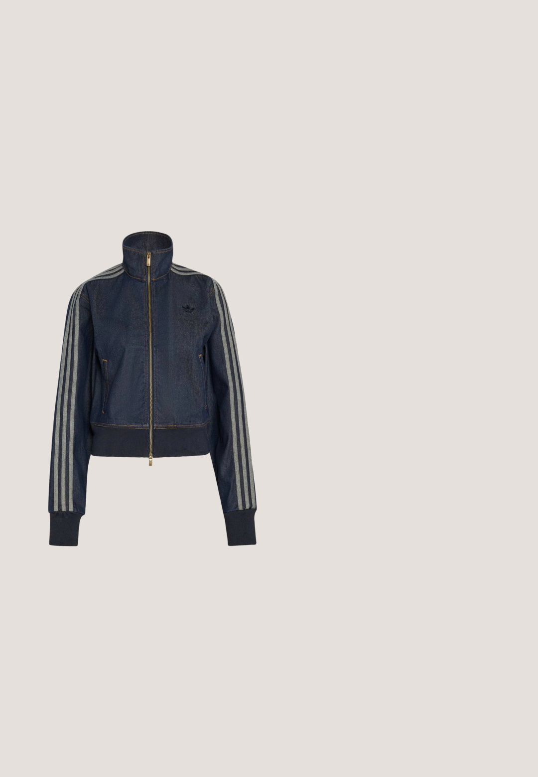 Chaqueta vaquera azul oscuro con cremallera, cuello alto, puños acanalados y tres rayas grises que recorren cada manga.; Camiseta Adidas de manga corta color gris claro con cuello redondo y pequeño logo blanco de Adidas en el pecho, mostrada sobre un fondo liso.; Pantalones de color azul marino, ligeros, con cintura elástica y cordón ajustable, con franjas blancas laterales y un pequeño logo en la parte delantera. Diseño de corte holgado.; Zapatillas de cuero blancas con rayas negras, suela de goma, puntera redonda, cierre de cordones y caperuza de ante gris suave.; Bolso bandolera gris de tela Adidas con correa negra ajustable y solapa frontal con parche con el logo de Adidas.; Collar de cadena plateada con una pequeña sección enlazada en la parte delantera y un cierre ajustable sobre un fondo claro y sencillo.