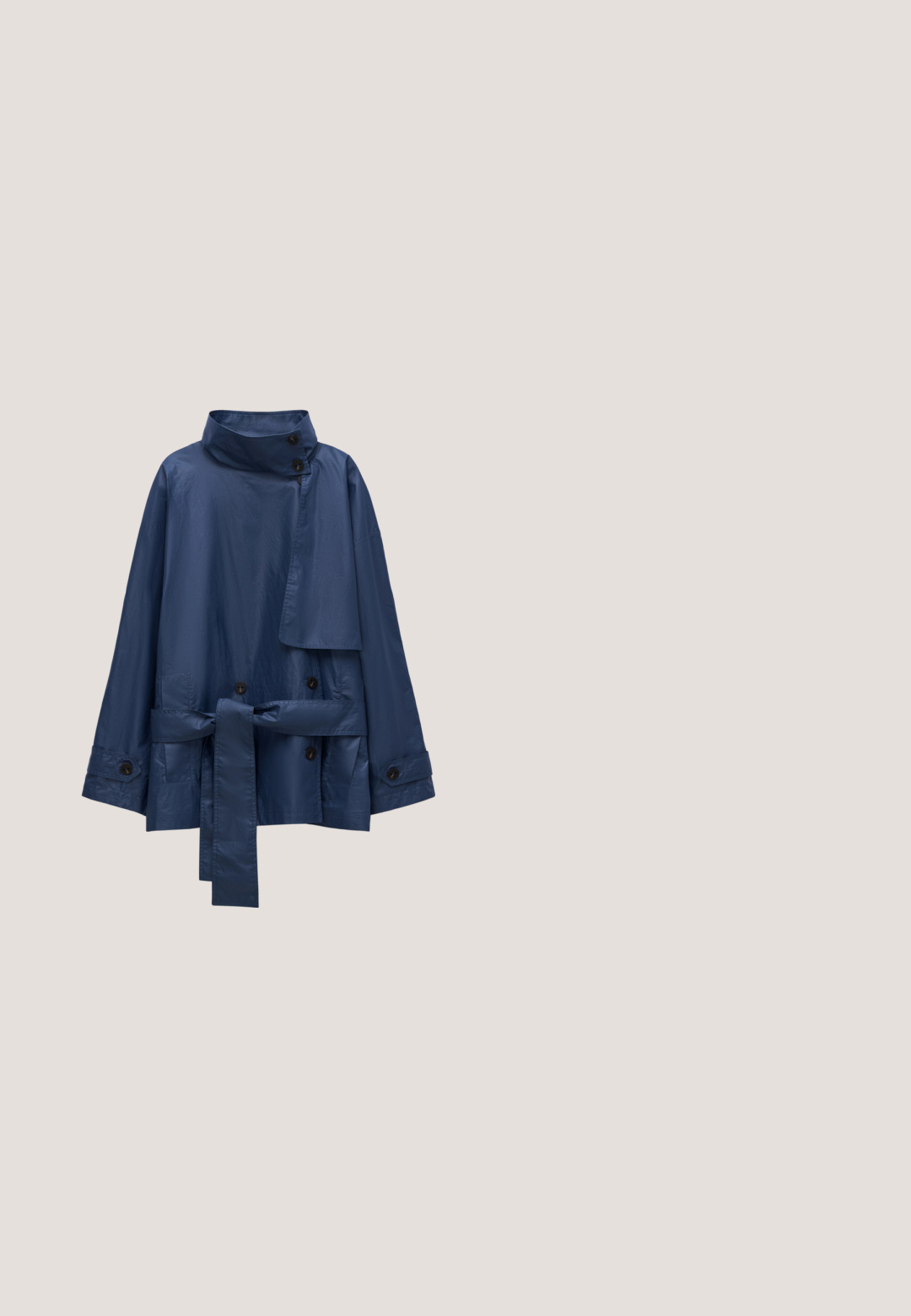 Marineblauwe waterdichte jas met een hoge kraag, dubbele knoopsluiting aan de voorkant, zakken met details en een tailleceintuur. Gladde textuur met knopen.; Marineblauwe langemouwen top met een hoge mock neck. Gemaakt van een gladde stof, met raglanmouwen en omgeslagen manchetten. Eenvoudig, ongecompliceerd ontwerp.; Marineblauwe broek met wijde pijpen, gemaakt van een zachte, rekbare stof met een elastische tailleband. Heeft een gladde textuur en een losse, vloeiende silhouet.; Dames schoen in marineblauw lakleer met lage blokhak, spitse neus en gouden kettingdetail op de wreef.; Zwarte leren handtas met twee handvatten, een voorvak van suède met gouden gesp en een afneembare schouderriem met gouden kettingdetail.; Gouden oorringen met onregelmatige halve maanvormen gevuld met glanzende donkerblauwe emaille, gepresenteerd op een witte achtergrond.