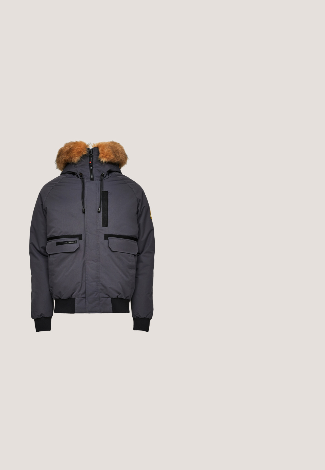 Isolierte graue Parka mit fellgefütterter Kapuze, schwarzen Reißverschlüssen, Fronttaschen mit Klappen und gerippten Bündchen an den Ärmeln und am Saum.; Schwarzer Kapuzenpullover aus Baumwollmischung, mit geprägtem Logo, verstellbaren Kordeln und Fronttasche. Gerippte Bündchen und Saum.; Schwarzes, langärmeliges Hemd aus Baumwolle mit mittigem Logo und großen Textgrafiken entlang der Ärmel in kontrastierenden Farben.; Schwarze Cargohose aus Baumwollmischgewebe mit weitem Bein, zwei Seitentaschen und Knopfverschluss an der Taille.; Schwarze hochgeschnittene Sportschuhe mit einer strukturierten Synthetik-Oberfläche, ausgestattet mit Metallösen, schwarzen Schnürsenkeln und einer Gummisohle mit Traktionsmustern.; Kompakte rechteckige graue Stofftasche mit einer vorderen Reißverschlusstasche und schwarzen Reißverschlussgriffen, auf der Vorderseite mit dem Aufdruck "Karl Lagerfeld Jeans".