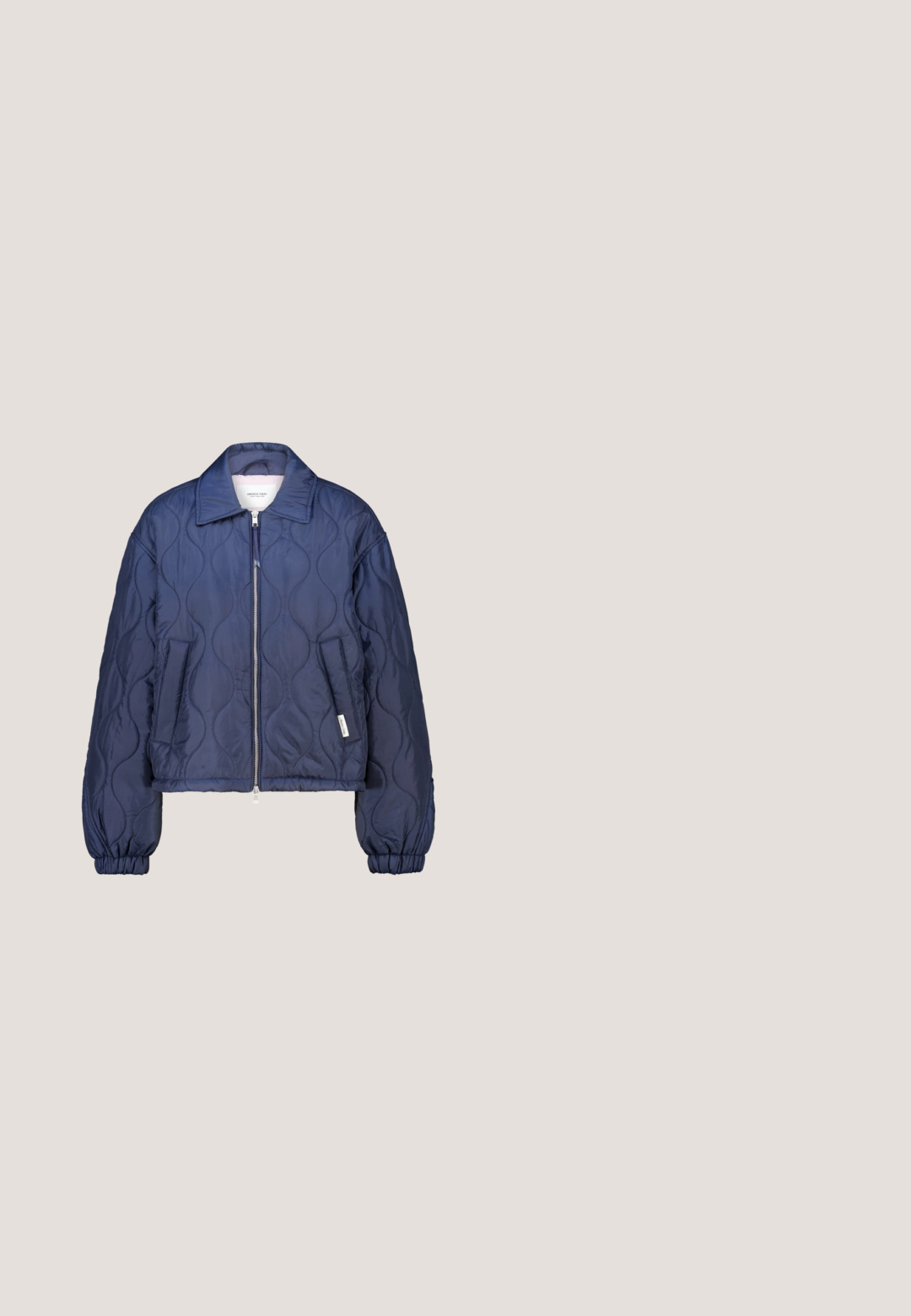 Marineblauw doorgestikt jack met rits aan de voorkant, kraag, elastische manchetten en twee zijzakken.; Marineblauwe sweatshirt met ribgebreide manchetten en halslijn, met witte fleece letters die "PARIJS" op de voorkant lezen.; Lichtblauw geribd mouwloos cropped topje met ronde halslijn en verstelbare zijstrikken bij de zoom.; Lichtblauwe sweatpants met elastische tailleband en boorden, rechte pasvorm, zonder zichtbare logo's of zakken.; Lichtblauwe sportschoen met een bovenwerk van mesh, rubberen zool en gestructureerde accenten. Heeft veters en een trekband bij de hiel.; Lichtblauwe gewatteerde laptoptas met dubbele handvatten en een afneembare schouderriem, met een klein embleem in de onderste hoek.