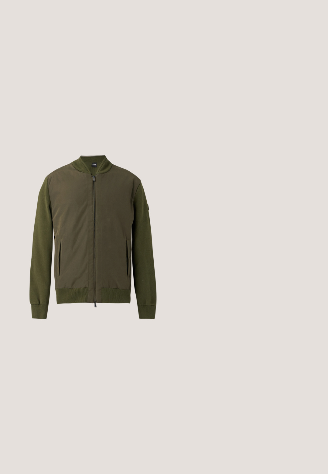 Veste bomber vert olive à fermeture éclair avec poignets, col et bas côtelés, et poches latérales.; Pull uni vert foncé à manches longues et col rond, avec poignets et ourlet côtelés, présenté sur un fond gris clair.; Polo vert foncé à manches courtes avec col, patte de boutonnage et logo « Les Deux » discrètement brodé sur la poitrine gauche.; Jean en denim bleu avec des détails délavés sur les cuisses et les genoux, style classique à cinq poches, coupe droite.; Botte Chelsea en cuir marron avec panneaux élastiques sur les côtés, une languette à l'arrière et un petit talon empilé. Texture lisse avec bout arrondi et un design minimaliste.; Petit sac bandoulière rectangulaire marron avec texture à motifs, patch logo devant, fermeture éclair et large bandoulière réglable.