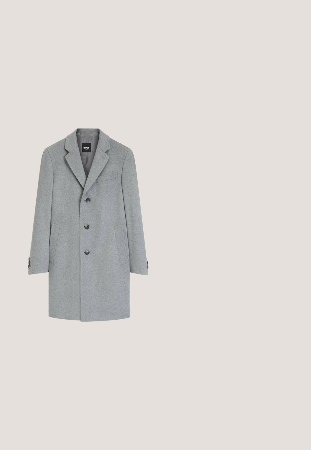 Abrigo de lana gris claro de un solo pecho con solapas con muesca, tres botones delanteros, dos bolsillos laterales y un bolsillo en el pecho.; Jersey de cuello alto tejido de color gris claro con mangas largas y puños y bajo acanalados, colocado plano sobre un fondo blanco.; Camisa polo de manga larga blanca en tejido texturizado, con cuello y tapeta de tres botones en un sutil color verde.; Pantalones gris claro de pierna recta con botón y trabillas, mostrados de frente sobre un fondo blanco.; Botas Chelsea negras de ante con paneles laterales elásticos, textura suave, punta redondeada y una pestaña en el talón. Suela de goma plana.; Neceser rectangular de cuero negro con asa en un lado y cierre de cremallera, mostrado sobre un fondo blanco.