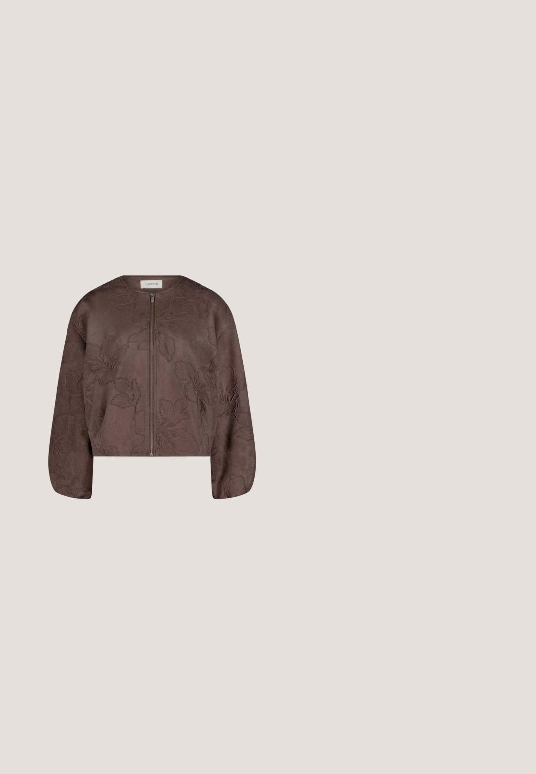 Veste en daim marron avec broderie fleurie, fermeture éclair à l'avant, encolure ronde et manches longues légèrement bouffantes.; Blouse crème avec boutons à l'avant, motif abstrait de feuilles marron, épaules bouffantes et manches trois-quarts.; Pantalon marron droit avec taille élastique et détail de couture à l’avant, présenté sur fond blanc.; Chaussure à bride arrière bicolore beige et noire avec un bout pointu, un talon plat et un détail de sangle croisée. Texture en cuir lisse.; Sac à main rectangulaire en cuir marron avec deux bretelles et un motif géométrique cousu sur toute sa surface.; Bague en or brillant avec un design en spirale lisse et audacieux sur le dessus, présentée sur un fond blanc.