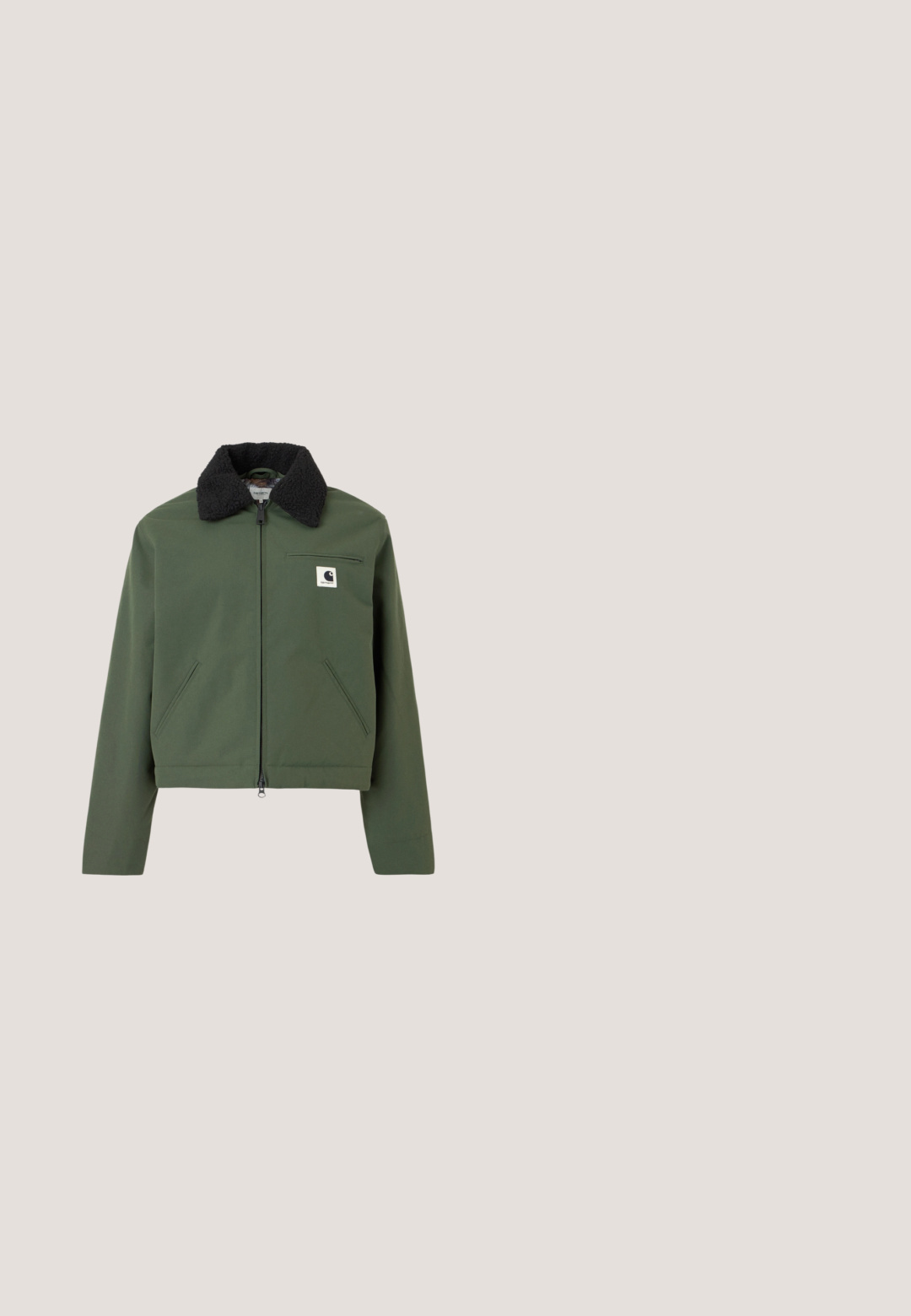 Chaqueta corta verde con un cuello negro y esponjoso. Presenta un cierre de cremallera, bolsillos laterales y en el pecho, fabricada con un material suave.; Camiseta de manga larga de color verde oscuro con cuello redondo y pequeño logo tonal en el pecho izquierdo, mostrada sobre fondo liso gris claro.; Vaqueros verdes de pierna ancha hechos de denim. Presentan una cintura alta, piernas rectas, bolsillos frontales y cierre de botón metálico.; Zapatillas de lona negras con tachuelas plateadas a lo largo de los lados, cordones blancos y una suela de goma crema. Diseño clásico de corte bajo con costuras en contraste.; Bolso bandolera Vans con estampado de camuflaje, bolsillo delantero con cremallera, correa negra ajustable y pequeño asa superior.; Pendientes de aro plateados con un acabado pulido, que presentan una forma redonda simple y un cierre de presión para un uso seguro.