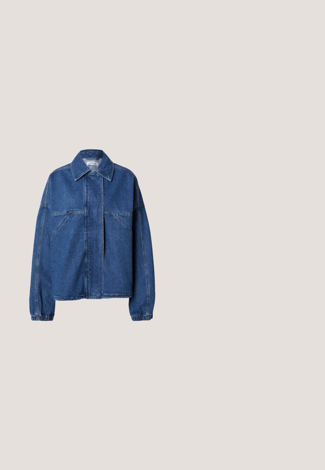 Veste en denim bleu avec un col pointu, une fermeture frontale cachée, des poches poitrine inclinées, des manches longues et des poignets élastiqués.; Chemise en denim bleu clair à manches longues avec fermeture par boutons, deux poches poitrine à rabats et un col classique pointu sur fond gris.; Un jean large en denim bleu clair présente une taille haute, une fermeture à bouton, un léger délavé et un design classique à cinq poches.; Bottes cheville en cuir marron avec panneaux latéraux élastiques, talon bloc, texture lisse et languette à l'arrière pour un enfilage facile.; Grand sac fourre-tout en tissu bleu foncé avec poignées en cuir marron et coutures jaunes, doté d'un petit patch rectangulaire en cuir à l'avant.; Ceinture en cuir marron enroulée avec une boucle dorée brillante et quatre anneaux dorés près de la boucle.