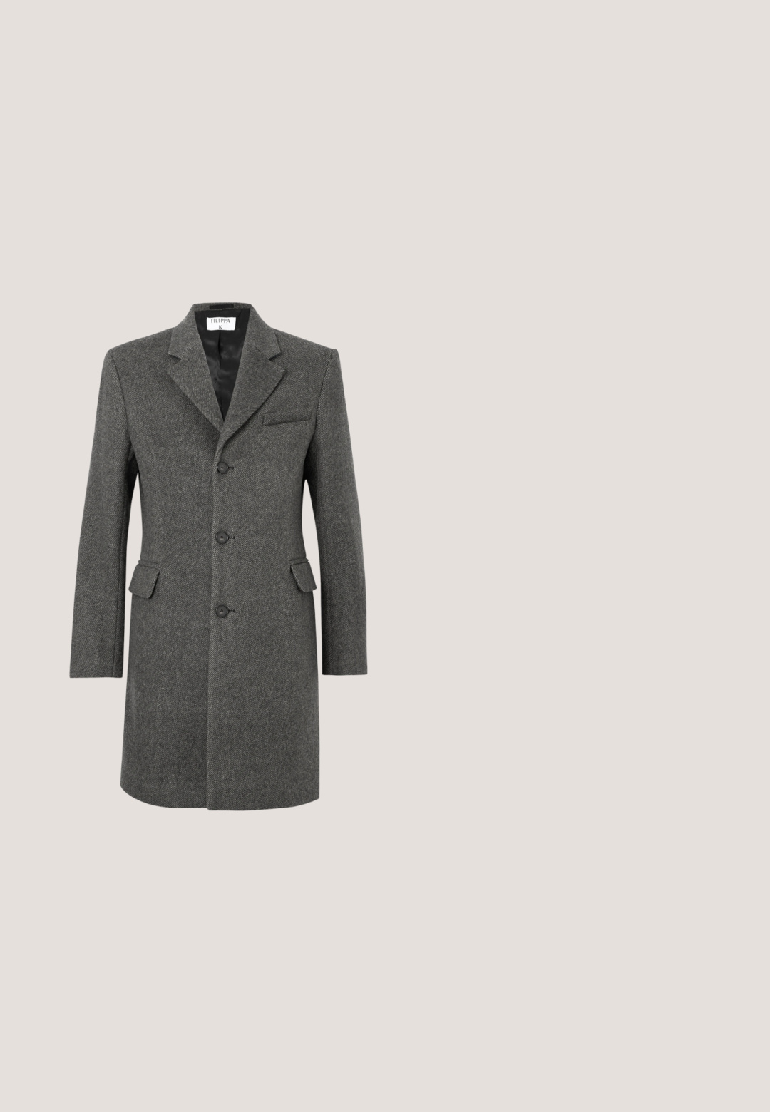 Manteau en laine gris foncé à simple boutonnage avec trois boutons, revers cranté, deux poches à rabat et une poche poitrine sur fond blanc.; Chemise à manches longues, marron clair, boutonnée, avec col pointu et boutons blancs, en tissu de lin texturé.; Pantalons larges en tissu marron foncé. Dotés d'une texture lisse, d'une taille structurée et de plis avant subtils.; Chaussure Oxford en daim brun foncé avec bout rapporté, lacets assortis et petit talon empilé sur un fond gris clair uni.; Trousse de toilette en cuir marron avec une surface texturée, fermeture éclair et une poignée latérale. Forme rectangulaire, bords lisses, détail de marque minimal.; Ceinture en cuir tressé marron foncé avec boucle rectangulaire argentée et patch en cuir embossé de "Tiger of Sweden" sur fond blanc.