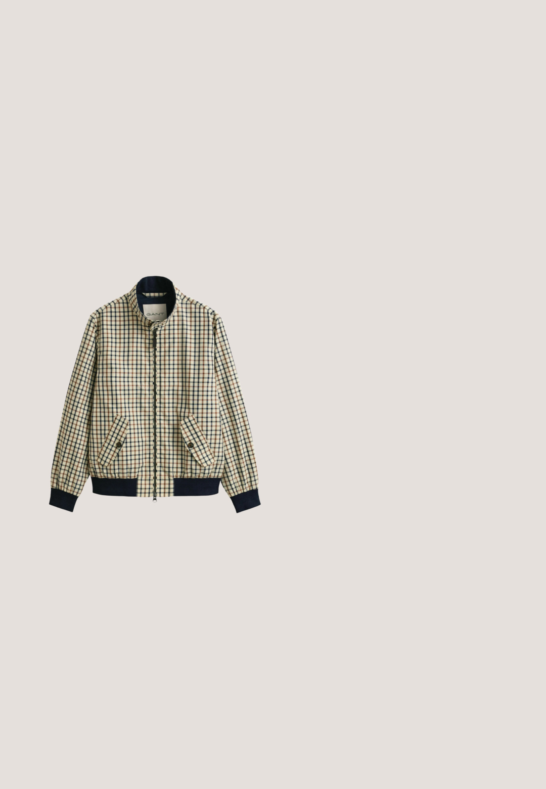 Beige jas met blauw, bruin en zwart ruitpatroon, ritssluiting aan de voorkant, schuine klepzakken met knopen en marineblauwe geribbelde manchetten en zoom.; Beige pullover met lange mouwen, een kwart ritssluiting en een klein geborduurd logo op de linkerborst, voorzien van geribbelde manchetten en zoom.; Beige katoenen T-shirt met korte mouwen en ronde hals, met een subtiel "GANT"-logo geborduurd op de linkerborst.; Donkerblauwe denim jeans met een recht model, vijf zakken en contrasterende stiksels op de naden. Gladde stofstructuur.; Bruine leren enkellaarzen met een gladde textuur, witte rubberen zool en zwarte veters. Voorzien van een trekhaak aan de achterkant en Contrasterende stiksels.; Lichtbruine canvas draagtas met donkerbruine leren handvatten en een voorvak met ritssluiting, rechthoekige vorm en een labelpatch onder de rits.
