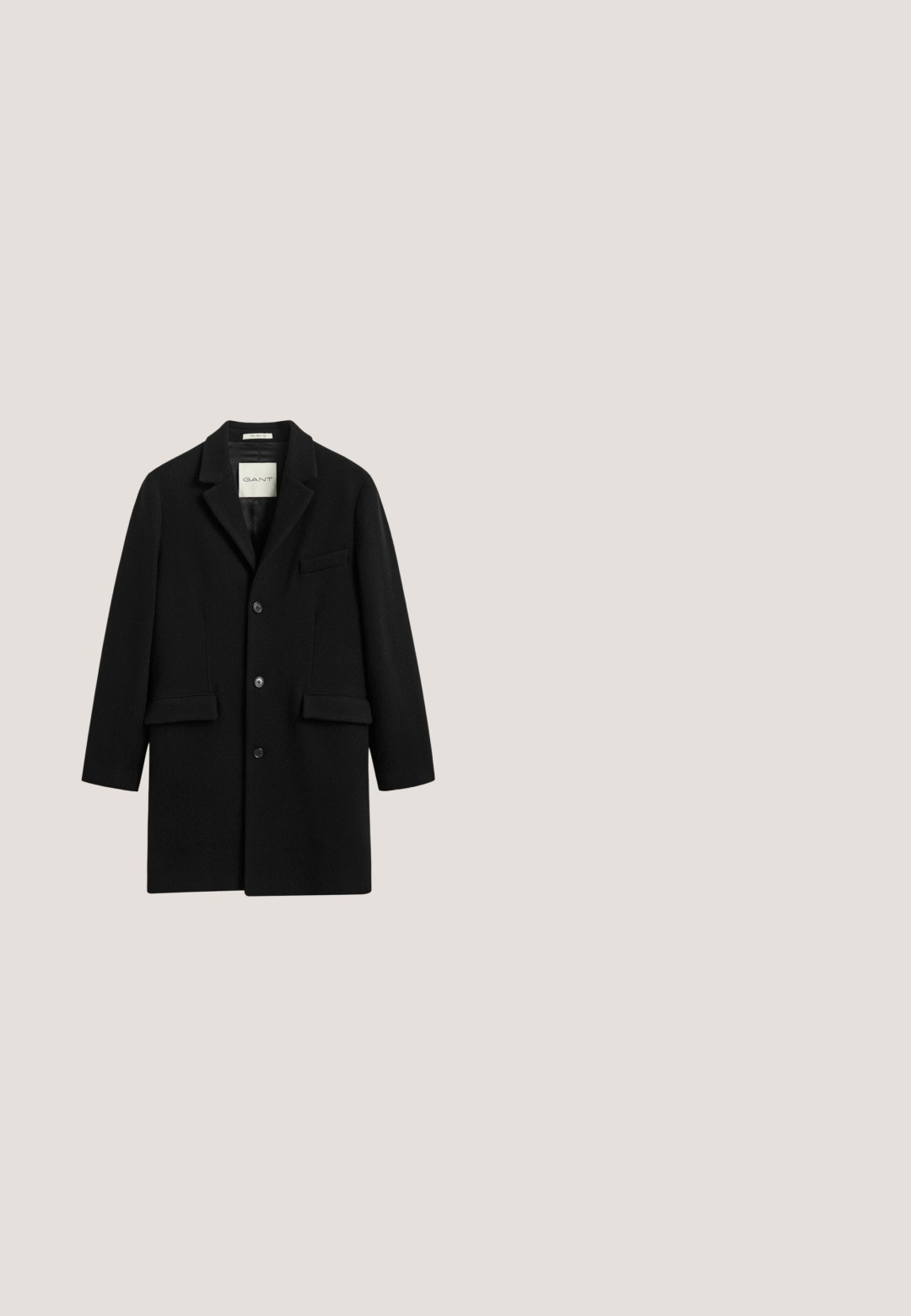 Abrigo de hombre de lana negra con tres botones, solapa con muesca y dos bolsillos delanteros con solapa.; Polo negro de manga larga hecho de tejido suave, con un collar clásico, tres botones y puños y dobladillo acanalados.; Camisa negra de manga larga con botones, cuello y puños, mostrada extendida sobre un fondo blanco.; Pantalones negros de tejido liso, con dos bolsillos laterales, cierre de botón y diseño de pierna recta. Ajuste minimalista y entallado.; Botas Chelsea negras de cuero con paneles laterales elásticos y un tirador. Textura suave, punta redondeada, suela plana de goma.; Funda para portátil de cuero negro con bolsillo frontal con cremallera y pequeño logotipo encima de la cremallera, sobre un fondo blanco.