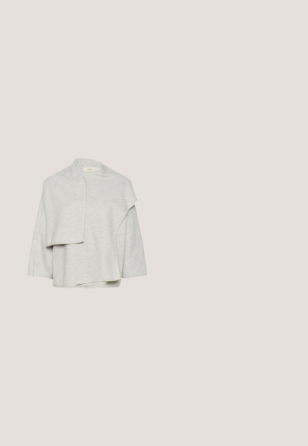 Suéter de punto gris claro con un diseño drapeado único. Presenta un cuello asimétrico doblado y mangas anchas, con una textura suave.; Suéter de cuello alto beige con mangas largas, cuello y puños acanalados, patrón de tejido texturizado, con botones decorativos en el hombro izquierdo.; Pantalones de pierna ancha en gris oscuro con una tela texturizada, que cuentan con un frente plano, presillas para cinturón y un dobladillo limpio, adecuados para vestir formal o casual.; Zapato negro de charol con tacón bajo, punta afilada, tira en T y cierre de hebilla sobre fondo neutro claro.; Bolso de mano de gamuza gris con una forma suave y redondeada, una sola correa para el hombro y un hardware mínimo. Textura suave con un ligero brillo.; Anillo abierto de plata pulida con extremos redondeados y lisos que se miran entre sí sobre un fondo blanco.