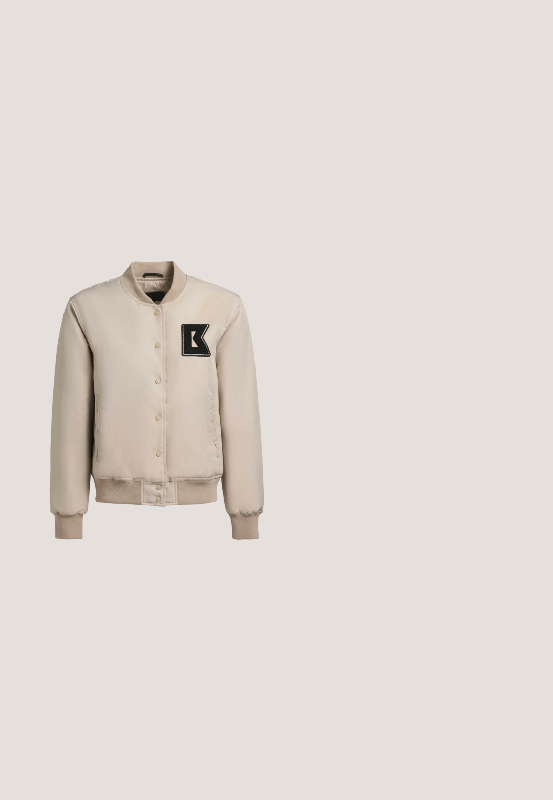 Chaqueta bomber beige con cuello y puños acanalados. Con botones a presión, bolsillos laterales y una letra 'K' bordada en negro en el pecho.; Camisa blanca de manga larga con un gráfico de denim en el pecho en diferentes tonos de azul, un acento marrón y cuello redondo.; Jeans de mezclilla de color azul claro de pierna ancha con una cintura alta, pliegues en la parte delantera y un dobladillo sin terminar para un look casual.; Zapatilla deportiva rosa y blanca con el logo "CK" flotando sobre una superficie de tabla de madera con piedras pequeñas, en un entorno al aire libre con vegetación y una pared de concreto.; Bolso rectangular de ante color cuero con correa de hombro ajustable y logo en escritura dorada "Karl" en la solapa frontal.; Anillo de oro en forma de corazón con un acabado suave y pulido, que presenta líneas curvas y elevadas, además de un acento redondeado en la parte superior.