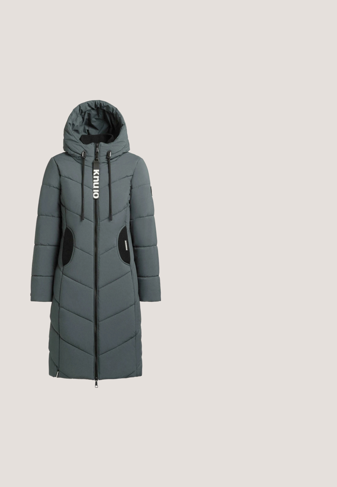 Grauer gepolsterter Mantel mit Reißverschluss vorne, Kapuze und Chevron-Steppung. Verfügt über schwarze Akzente an den Taschen und ein Logo am Reißverschluss.; Türkisfarbenes Sweatshirt mit langen Ärmeln und Rundhalsausschnitt, mit strukturiertem horizontalem Wellenmuster und gerippten Bündchen, vor weißem Hintergrund dargestellt.; Türkisfarbene Schlaghose aus weichem Samtstoff mit hohem Bund und glatter Textur, die sich zum Saum hin verjüngt und leichte Öffnungen aufweist.; Schwarze Sneaker aus strukturiertem Leder, mit einer dicken weißen Sohle, goldfarbenen Schnürsenkeln und einem subtilen geprägten Muster im Obermaterial.; Grüne Ledertasche mit doppelten Griffen, goldenem "19V69 Italia"-Logo und einem Schlüsselanhänger mit einer gelben Kette, Tennis-Schläger-Anhänger und Perlen.; Goldkette mit einem ovalen Türkisanhänger. Der Anhänger ist in eine glatte Fassung gefasst, während die strukturierte Goldkette mit kleinen Goldperlen durchsetzt ist.