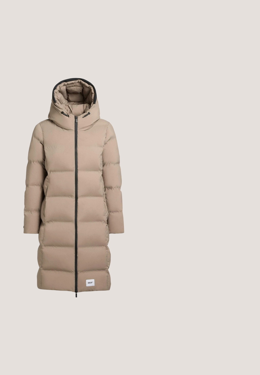 Beige pufferjas met hoge kraag, ritssluiting en zijzakken. Heeft een gestept ontwerp met horizontale stiksels en een logo-label.; Lichtbeige hoodie met een trekkoordkap, lange mouwen en een voorzak. Heeft een zachte textuur en subtiele stiksels.; Beige korte mouw oversized t-shirt met een ronde halslijn en een losse pasvorm.; Bruine taps toelopende joggingbroek met elastische tailleband en enkels boorden, met een voorste trekkoord.; Beige gebreide vetertrainer met witte zool en transparante luchtkussen bij de hiel, ontworpen voor casual gebruik.; Zachte, gewatteerde taupekleurige schoudertas met brede lusvormige handgreep en golvende stikdetails op een gladde stoffen oppervlakte.