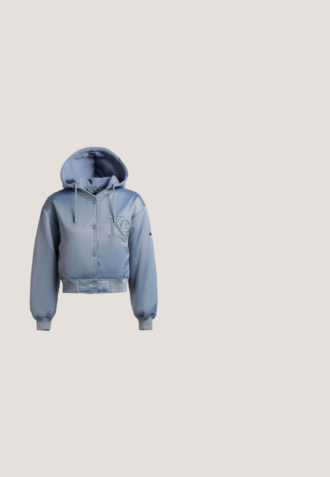 Lichtblauw satijnen cropped hoodjack met drukknopen, geribbelde boorden en zoom, en geborduurd "Khujo"-logo op de borst.; Lichtroze geribd T-shirt met een ronde hals, korte mouwen en een klein blauw "HUGO"-logo in het midden van de borst. Zachte stoftextuur.; Lichtblauwe denim jeans met een licht vervaagde afwerking, voorzien van een bloemenpatroon, vijf zakken en een recht gesneden pijp.; Lichtroze suède sneaker met een witte rubberen zool, ronde neus en witte hielaccent. Beschikt over platte veters en minimale branding aan de zijkant.; Oranje katoenen tas met rafelige randen en handvatten, met "PINKO" geborduurd aan de voorkant.; Goudkleurige ketting met een rechthoekige hanger met een grijs hartvormig element. De ketting heeft een delicate textuur en is in lengte verstelbaar.