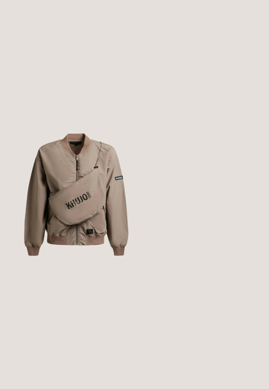 Beige bomberjack met ritssluiting, geribbelde manchetten en kraag, inclusief een bijpassende crossbodytas met "KHUJO 2001" in het zwart gedrukt.; Zwarte cropped hoodie met een opvallende afbeelding van een schedel omringd door gestileerde takken en de tekst "SKULL OF THE NIGHT" in goud.; Wit T-shirt met korte mouwen met zwarte schouderstrepen, gestreepte zwarte en witte kraag en zwarte gedrukt logo op de borst.; Hooggeoriënteerde, skinny jeans in middelblauwe denim. Voorzien van een sluiting met vijf knopen, voorzakken en een licht vervaagde afwerking.; Witte leren sneakers met geperforeerde neus, gouden accenten en platte veters, gecombineerd met beige broek op een gestructureerde gele ondergrond.; Zwarte nylon heuptas met een strak ontwerp, voorzien van een driehoekig logo-plaatje, metalen rits en een brede band voor een veilige bevestiging.