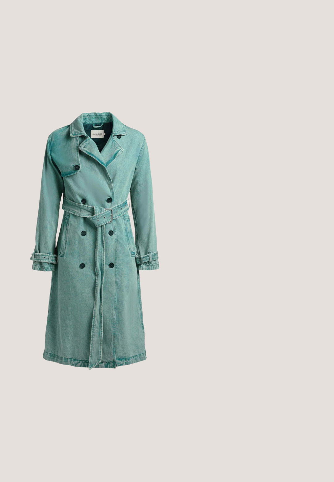 Lange groene denim trenchcoat met dubbele knopenrij, een tailleceintuur, manchetten en een brede reverskraag.; Groen satijnen shirt met lange mouwen, een knoopsluiting aan de voorkant, een enkele borstzak en een gladde textuur. Kraag en manchetten zijn van dezelfde stof.; Broek met wijde pijpen en hoge taille in fel neonroze, met plooien, riemlussen en een voorzijde met knoop- en ritssluiting.; Zilveren satin hoge hak schoen met spitse neus, enkelbandje en slanke stiletto hak. Gladde textuur met een tan kleurige binnenzool.; Zwarte handtas met golvend patroon, meerkleurig bloemenmotief en gevlochten rood handvat met kwastaccenten.; Een houten ketting met lichtblauwe ronde stenen en facet geslepen amber vierkante accenten, met een gouden ketting en sluiting voor het afsluiten.