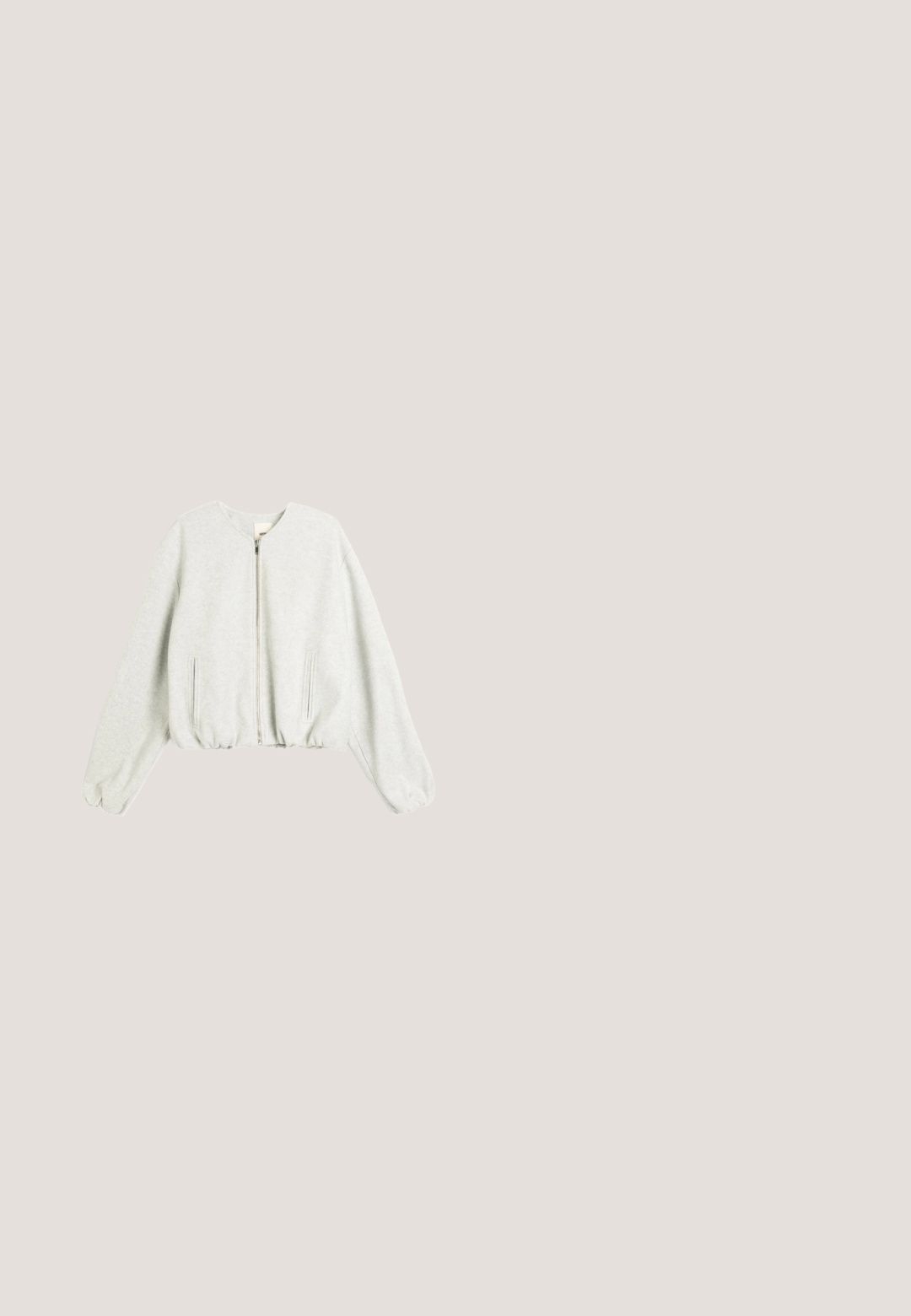 Grijze cropped sweatshirt van zacht materiaal, met een rits, ribgebreide manchetten en zijzakken. Eenvoudige ronde halslijn en een relaxte pasvorm.; Korte mouwen, grijs katoenen T-shirt met een ronde hals en een decoratieve lichtgekleurde strikborduring op de linker borst.; Grijze geplooide broek in een glanzende, gestructureerde stof met een knoopsluiting en een merklabel. Bevat subtiele tonale variaties.; Glanzende grijze sneakers met een bovenwerk van suède, een zwarte rubberen zool en een zilveren doodskop en gekruiste botten detail aan de zijkant. Vetersluiting.; DrachenLeder Handtas - silberfarben; Zilverkleurige armband met ronde heldere kristallen, geplaatst in een herhalend geometrisch patroon, voorzien van een sluiting en een verstelbare kettinguitbreiding.