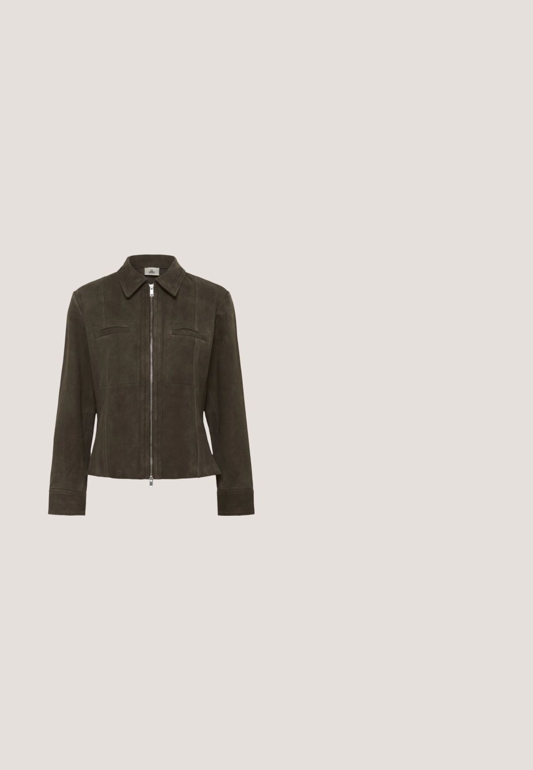 Veste en daim marron avec fermeture éclair à l'avant, col et deux poches poitrine. Présente une coupe ajustée et une texture lisse.; Combinaison courte marron foncé avec boutons sur le devant, col chemise, taille élastique et pantalons larges.; Mules en imprimé léopard avec un petit talon aiguille noir. Tige en tissu doux avec un détail de nœud à l'avant et une semelle plate lisse.; Lunettes écaille de tortue avec une monture carrée, dotées de verres transparents et d'un motif texturé. Les branches ont un design fin et épuré.; Sac fourre-tout en daim marron avec deux anses en cuir noir. Texture douce, haut arrondi et un intérieur spacieux. Aucun matériel ou embellissement visible.; Boucles d'oreilles créoles en ton or avec une finition lisse et brillante. Forme arrondie et allongée pour une élégance moderne. Dimensions non spécifiées.