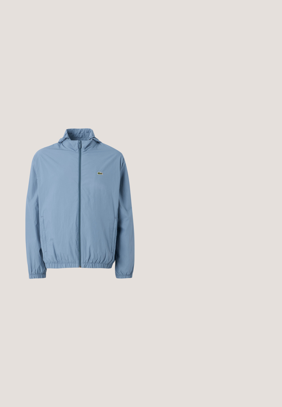 Chaqueta de cremallera azul claro con capucha, puños elásticos y cinturilla. Presenta un pequeño logo verde en el bolsillo izquierdo del pecho.; Sudadera blanca con capucha, bolsillo delantero y pequeño logotipo de cocodrilo verde en el pecho izquierdo, con cordón en la capucha y puños acanalados.; Polo de manga corta color melocotón con cuello y bordes de las mangas naranjas, logotipo azul en el pecho, tapeta de botones, extendido sobre fondo blanco.; Pantalones deportivos de color crema con cintura y puños elásticos, que presentan un pequeño logo de cocodrilo verde y un detalle de garabato dorado en el muslo izquierdo.; Zapatillas Lacoste que combinan ante gris y malla, con un acento azul, detalles texturizados y suela blanca. Incluye el texto de marca en el lateral.; Estuche rectangular para lápices de color rosa claro con cremallera negra y pequeño logo verde de cocodrilo en el lado delantero sobre un fondo liso.
