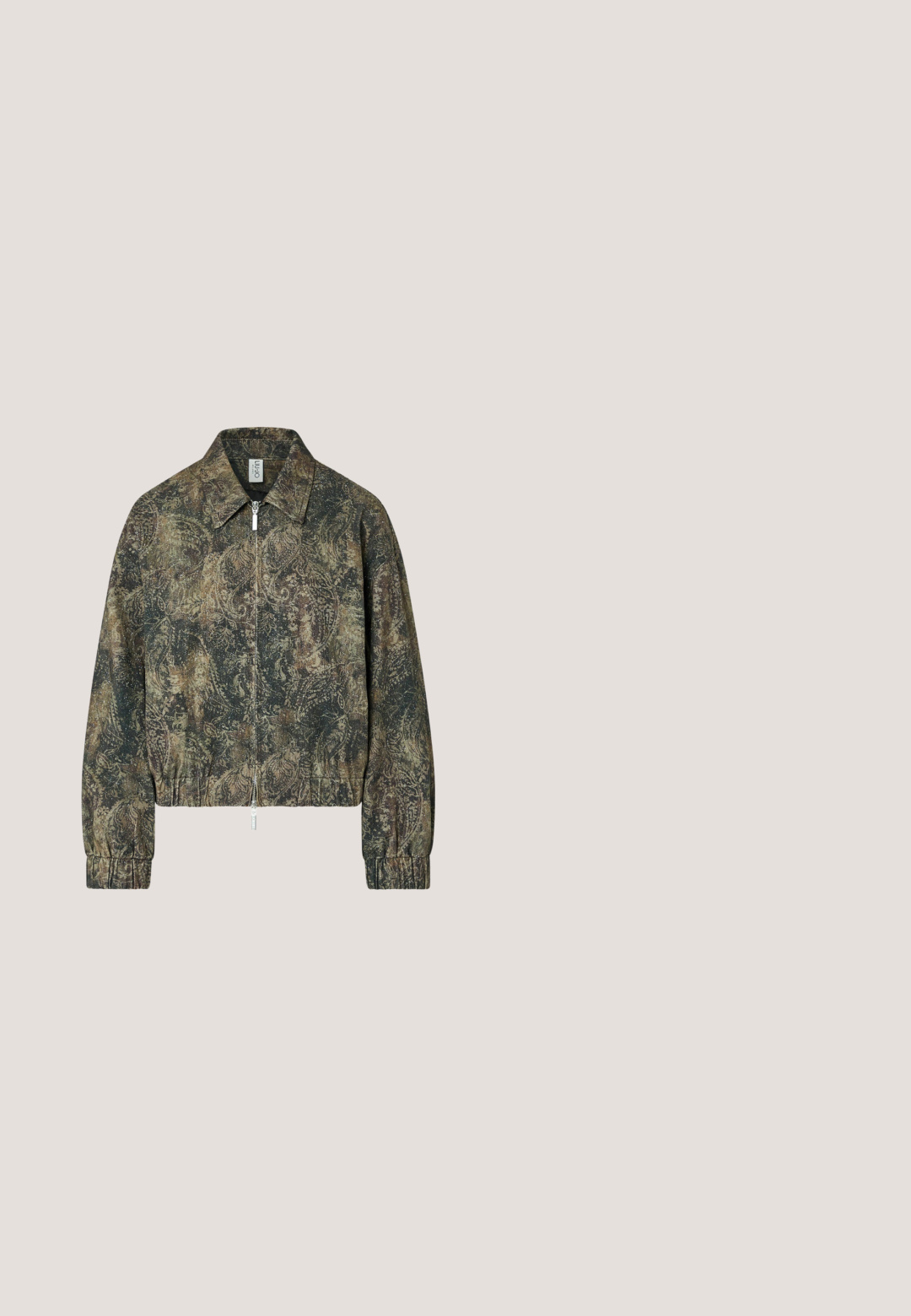Chaqueta de manga larga con cremallera y cuello en patrón paisley marrón y verde oscuro, puños y bajo elásticos, y tirador de cremallera plateado.; Vestido mostaza de un solo hombro con parches de encaje en crema y gris y una sección a rayas en crema y mostaza en el dobladillo.; Botas de tacón alto con estampado de leopardo marrón, con punta afilada y diseño ajustado. El material parece suave con una ligera textura.; Gafas de sol con montura de ojo de gato marrón con estampado y lentes oscuras, descansando sobre una superficie blanca.; Bolso bandolera de cuero negro con tachuelas y cremalleras doradas, con una correa ajustable y un pequeño bolso adjunto con la marca Steve Madden.; Brazalete tipo puño de oro abierto con segmentos redondeados y suaves en los bordes, acabado pulido y ligeramente texturizado.