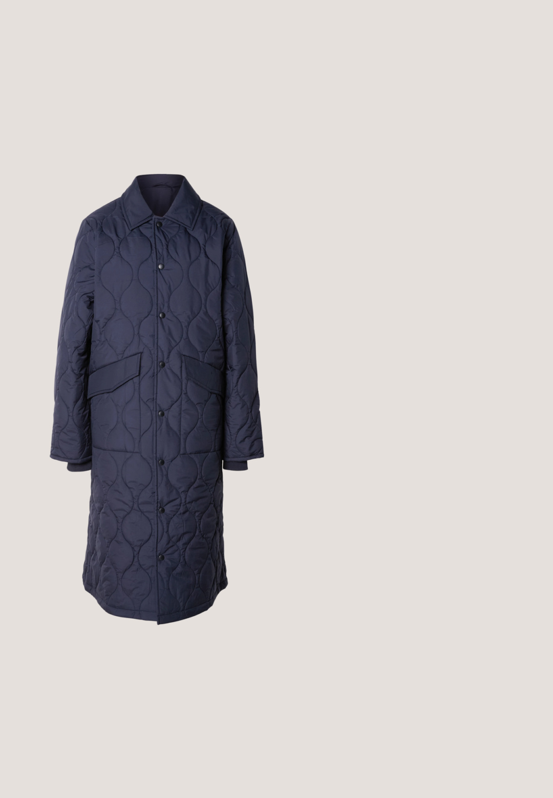 Manteau matelassé marine avec col, poches avant et fermeture à boutons-pression. Présente un motif ondulé distinct sur la texture du tissu.; Pull en tricot bleu marine à col ras du cou, doté de manches longues et d'un petit logo crocodile vert sur la poitrine.; Short en denim bleu clair avec ourlets effilochés, fermeture à bouton et zip à l'avant, passants de ceinture, et poches avant.; Baskets en cuir noir et beige avec lacets beiges et semelle en gomme, exposées sur un sol en carreaux de bois avec de la verdure et un mur en béton en arrière-plan.; Sac bandoulière noir en matériau lisse, avec une sangle incurvée et des accessoires dorés, doté d'une fermeture éclair et d'un logo embossé.; Une paire de petites boucles d'oreilles en forme de hoop rouges avec des détails rectangulaires facettés et des fermoirs en métal argenté sur un fond blanc.