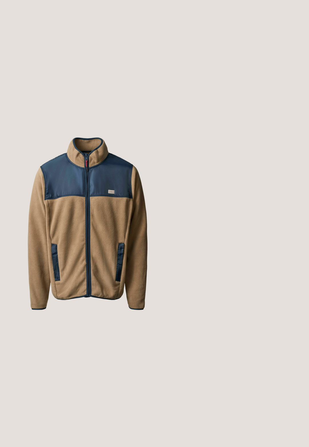 Mann mit mittellangen Haaren und Bart, der eine beige und marineblaue Fleecejacke, blaue Jeans und braune Lederstiefel trägt und vor einem schlichten Hintergrund steht.; Dunkelgrauer Fleece-Pullover mit hohem Kragen, halbem Frontreißverschluss sowie elastischen Bündchen und Saum. Verfügt über eine strukturierte, weiche Oberfläche.; Hellblaues Baumwoll-T-Shirt mit rundem Ausschnitt und kurzen Ärmeln. Es hat fettgedruckten, schwarzen Text: "TOM TAILOR" und weitere Branding-Details.; Dunkelblaue Denim-Jeans, von hinten gezeigt, mit zwei Gesäßtaschen, Kontrastnähten und einem braunen Lederpatch am Bund.; Braune Leder- und Wildleder-Ankle Boots mit runder Zehenform, kontrastierender weißer Sohle, Schnürdesign und kleinen dreifarbigen Akzentdetails.; Junger Mann in weißem Poloshirt und marineblauer Hose, der eine marineblaue und rote Reisetasche mit einem aufgenähten Abzeichen hält und vor einem weißen Hintergrund steht.