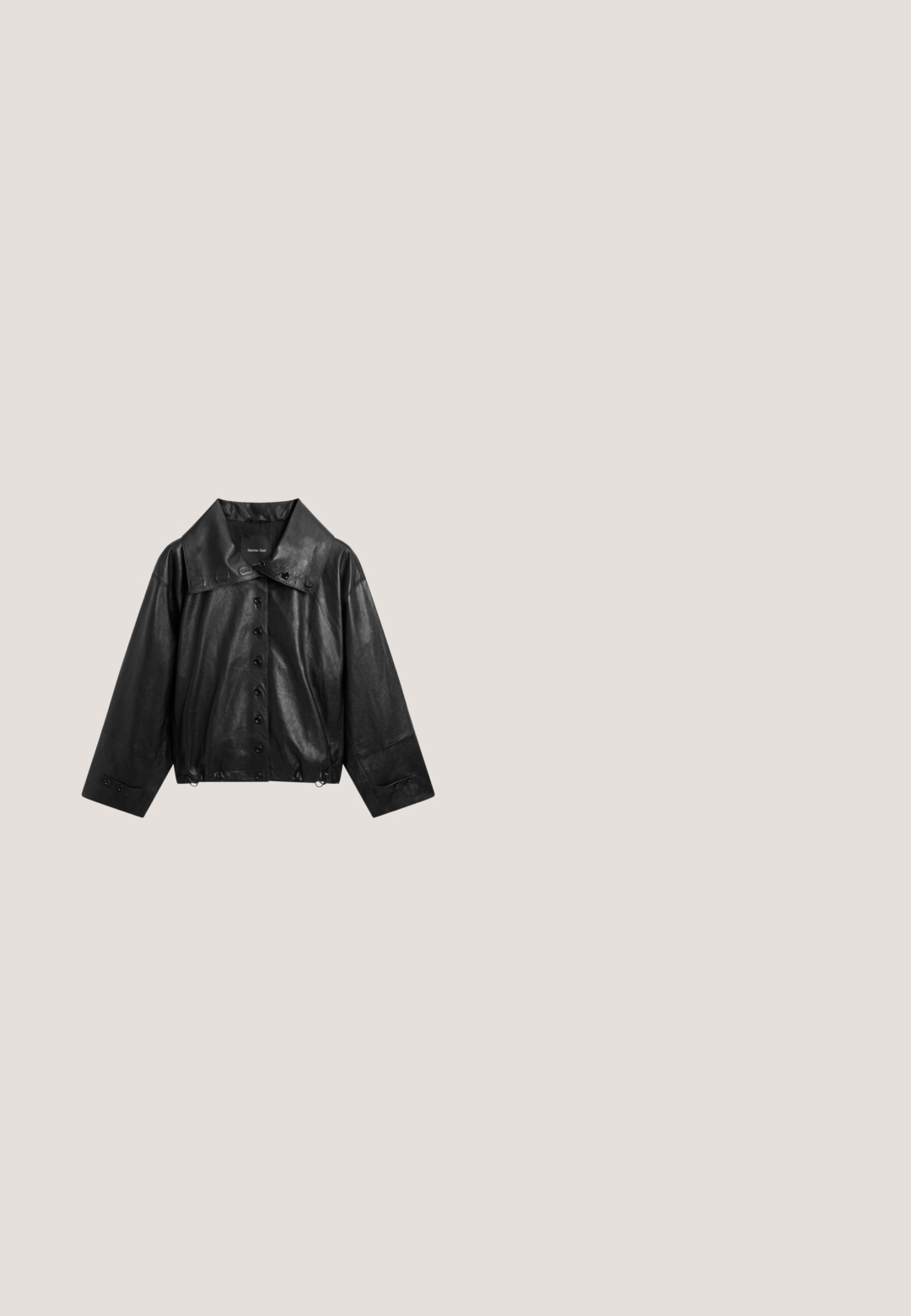 Schwarze Kunstlederjacke mit weitem Kragen, Knopfleiste vorne, langen Ärmeln und verstellbaren Manschetten.; Schwarzer gestrickter Kurzarmpullover mit Rundhals und geripptem Saum. Weicher Stoff, lockere Passform und minimalistisches Design. Keine Muster oder Verzierungen.; Schwarzer Denim-Stoff mit strukturierter Oberfläche, ausgestattet mit einer Fronttasche, Gürtelschlaufen und genähten Details entlang der Kanten.; Schwarzer Leder-Stiefelette mit leichtem Absatz, spitz zulaufender Spitze und metallischer Kappe. Schlichte Nahtführung und Zuglasche an der Rückseite.; Schwarze ovale Sonnenbrille mit dicken Fassungen und dunkel getönten Gläsern, vor weißem Hintergrund dargestellt.; Schwarze, glänzende Tasche mit runder Form und einem breiten Schultergurt; verfügt über einen Reißverschluss und eine durchgehend glatte Oberfläche.