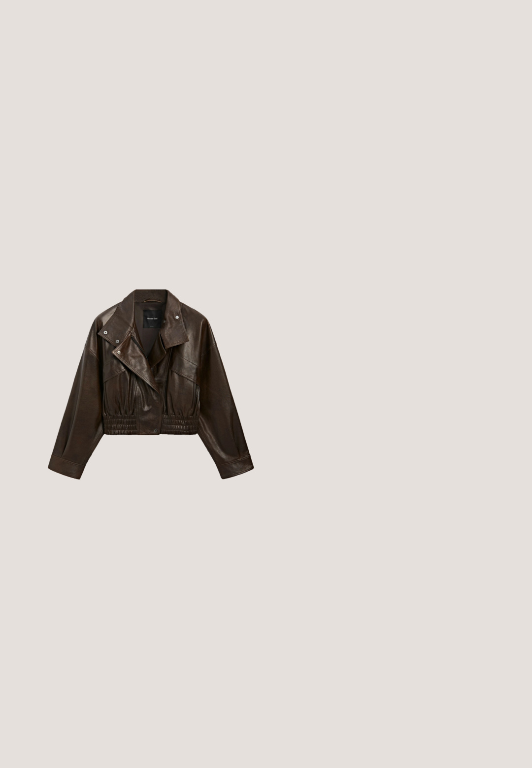 Mørkebrun croppet læderjakke med brede revers, trykknapper, lynlås foran og detalje med elastisk taljebånd.; Mørk brun langærmet t-shirt med rund hals, ensfarvet design, lagt fladt på hvid baggrund.; Mørkeblå denim buede bukser med høj talje, som har fem lommer og synlige stingdetaljer. Ren, minimalistik design.; Brune ruskinds ankelstøvle med en rund tå, tekstureret sidesøm og cremefarvet dekorativ syning. Har en lav platformssål med godt greb.; Ovale røde solbriller med klare linser og slanke brune stel. Designet har subtile kurver og minimalt hardware.; Blød sort ruskind skuldertaske med en enkelt bred strop og en rundet, let slap form.