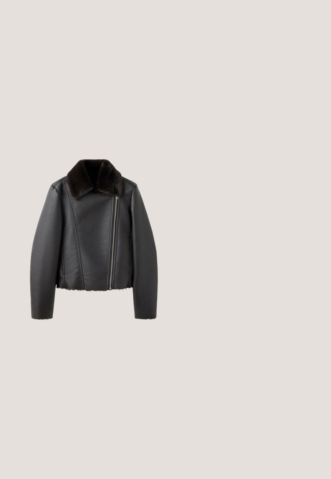 Schwarze Lederjacke mit asymmetrischem Frontreißverschluss und dunkelbraunem weichem Pelzkragen, langen Ärmeln sowie Pelzbesatz am Saum und an den Bündchen.; Marks & Spencer Strickpullover - black; Schwarz weit geschnittene Jeans aus Denim. Mit Reißverschluss, fünf Taschen und silberfarbener Hardware. Schlichtes Design, ohne Muster oder Akzente.; Schwarze Wildleder-Stiefelette mit spitzem Zehen und einem niedrigen Blockabsatz. Glatte Textur, minimalistisches Design und eine klare Silhouette.; Schwarze Lederschultertasche mit goldener Schnalle und Verschlussdetail sowie einem kleinen angehängten Etikett auf weißem Hintergrund.; Silberne Kettenhalskette mit fünf klaren Kristallakzenten, jeweils in Tropfenform, gleichmäßig entlang der Kette verteilt.