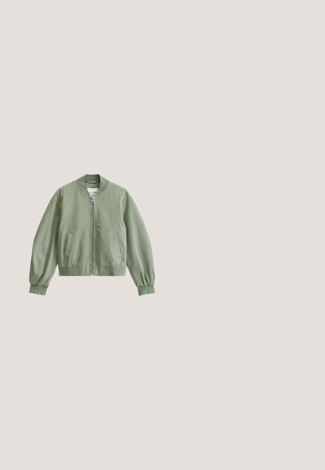 Khaki bomberjack met ritssluiting, elastische manchetten en zakken. Gemaakt van lichtgewicht materiaal met een gladde textuur.; Zwarte katoenen t-shirt met witte lijntekeningen van drie bloemen en de tekst "bloom wildly" eronder. Ronde hals en korte mouwen.; Lichtblauwe denim flare jeans met distressed details, vijf zakken, knoopsluiting en een rafelige zoom bij de enkels.; Witte lage sneaker met zijrits en veters, geplaatst naast een bruine ronde houten tafel met gestapelde boeken.; Kleine bordeauxrode leren schoudertas met geknoopte riem en ritssluiting aan de bovenkant tegen een effen lichte achtergrond.; Zes paar zilveren en groene stekers en creolen oorbellen, gerangschikt in twee verticale kolommen op een witte achtergrond.