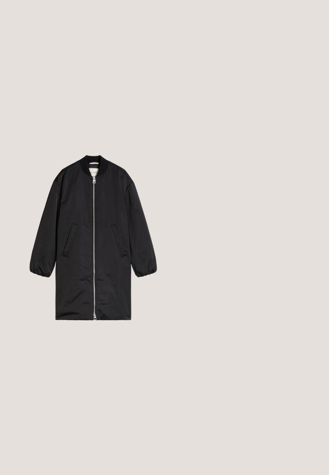 Veste bomber longue noire avec fermeture éclair intégrale à l'avant, col côtelé, poignets élastiques et deux poches avant inclinées, présentée sur fond blanc.; T-shirt à manches courtes et col rond de couleur bleu marine foncé, en tissu de coton doux. Design simple avec encolure et ourlet côtelés.; Pantalon noir à jambes larges en tissu doux, doté d'une taille élastique et d'une silhouette droite. Aucun motif ni ornement présent.; Mocassins en cuir noir avec un bout arrondi, un design cousu et un accent en nœud sur la tige. Talon bas et texture lisse.; Sac cabas en cuir noir avec des anses fines et une pochette zippée assortie, toutes deux étiquetées Marc O'Polo, sur un fond clair uni.; Boucles d'oreilles ton argent avec une forme organique lisse en goutte d'eau. Surface polie avec une courbure subtile et sans ornements visibles.